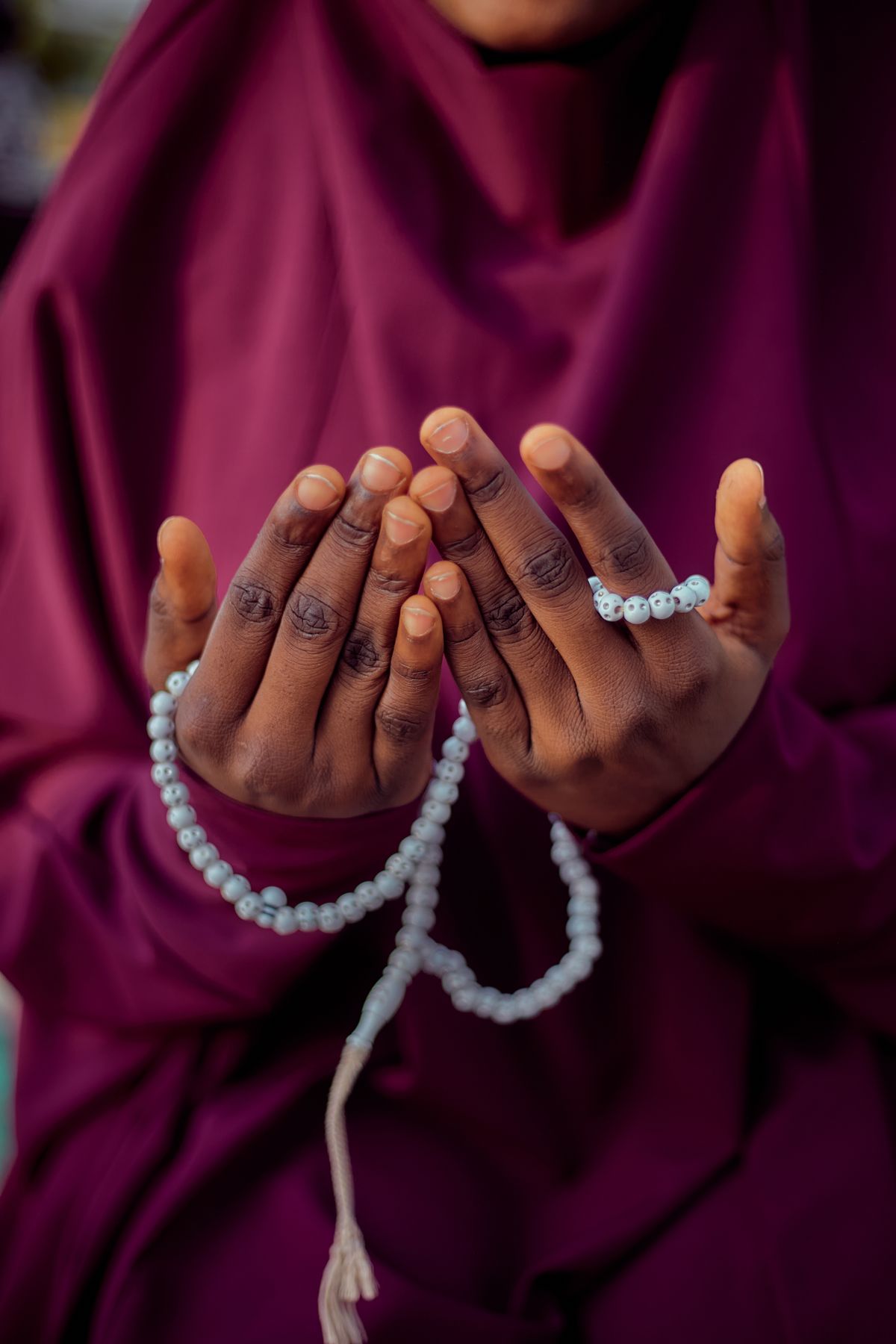 Person in Traditional Attire Holding Prayer Beads · Free Stock Photo