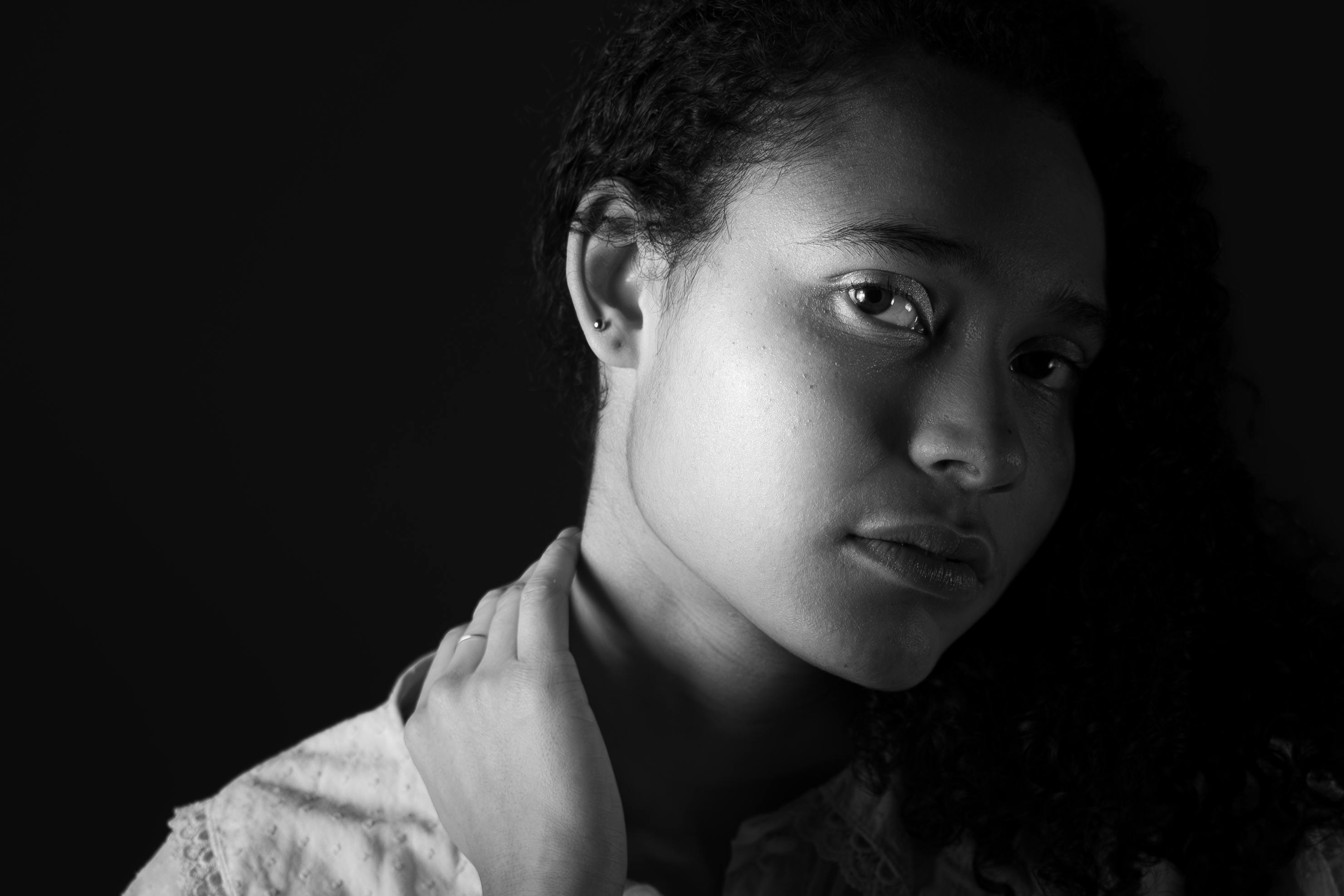 Kostenlos Eindrucksvolles Schwarz-Weiß-Porträt einer Frau mit lockigem Haar in einem Studio. Stock-Foto