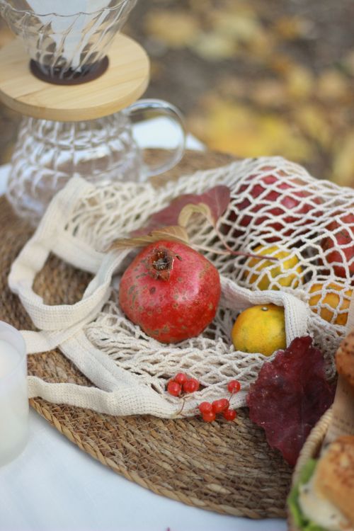 Free A rustic autumn still life featuring a pomegranate, apples, and a glass coffee dripper. Stock Photo