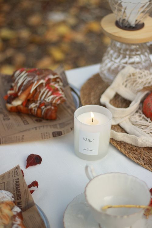 Free Cozy outdoor picnic featuring a candle, baked goods, and autumn vibes. Stock Photo