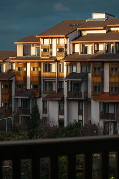 A warm evening glow highlights the modern architecture of an apartment building.