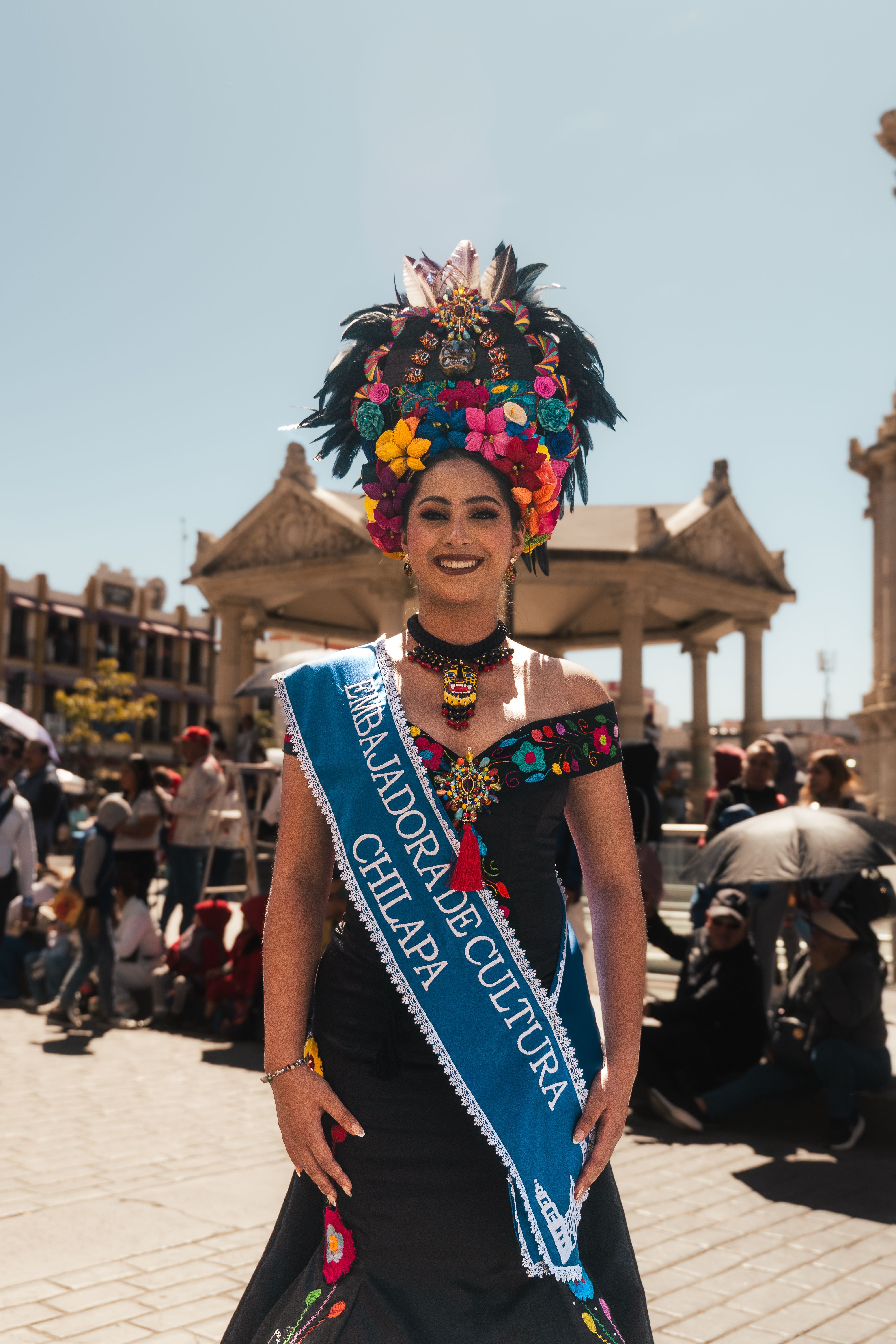 A vibrant cultural festival with a woman in traditional Mexican attire in Pachuca, Mexico.