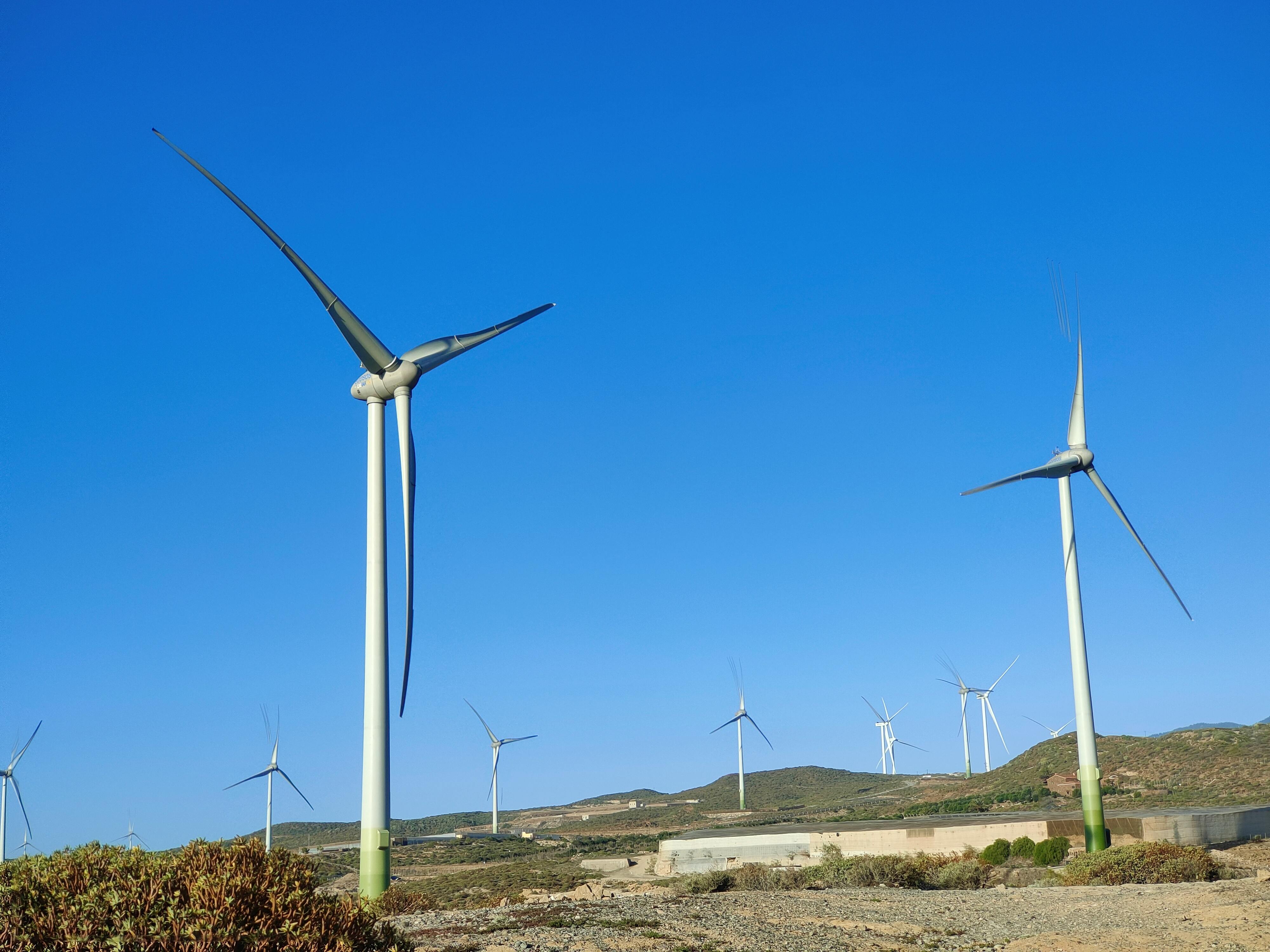 Gratis Vindmøller, der producerer ren energi i et åbent landskab under en klar blå himmel. Lagerfoto
