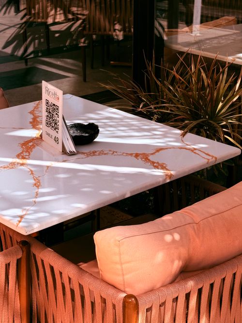 Free Chic modern cafe table in sunlight with vibrant plants, El Sheikh Zayed City. Stock Photo