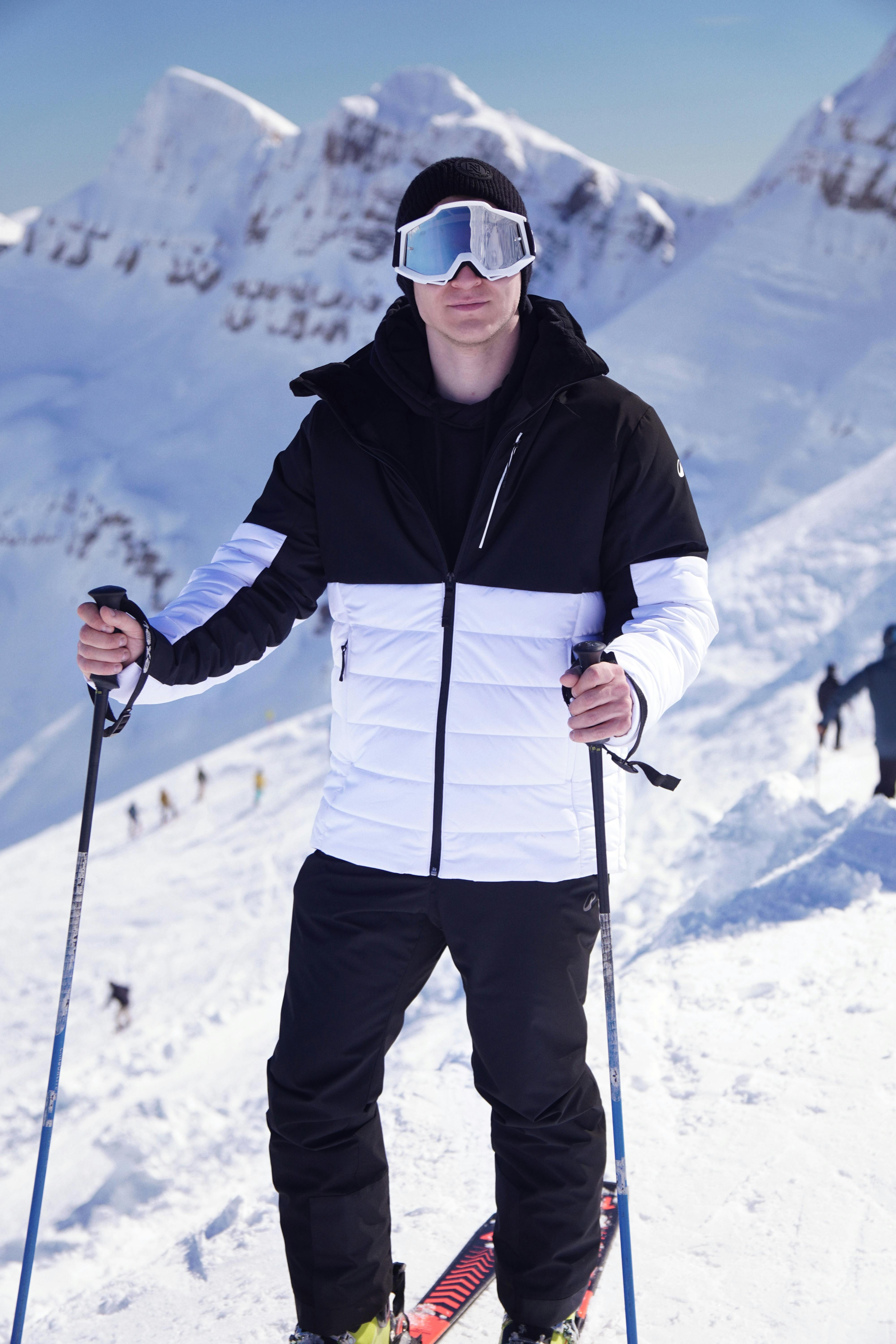 Kostenlos Ein Skifahrer in Winterausrüstung posiert an einem schneebedeckten Berghang und präsentiert damit die Wintersportart. Stock-Foto