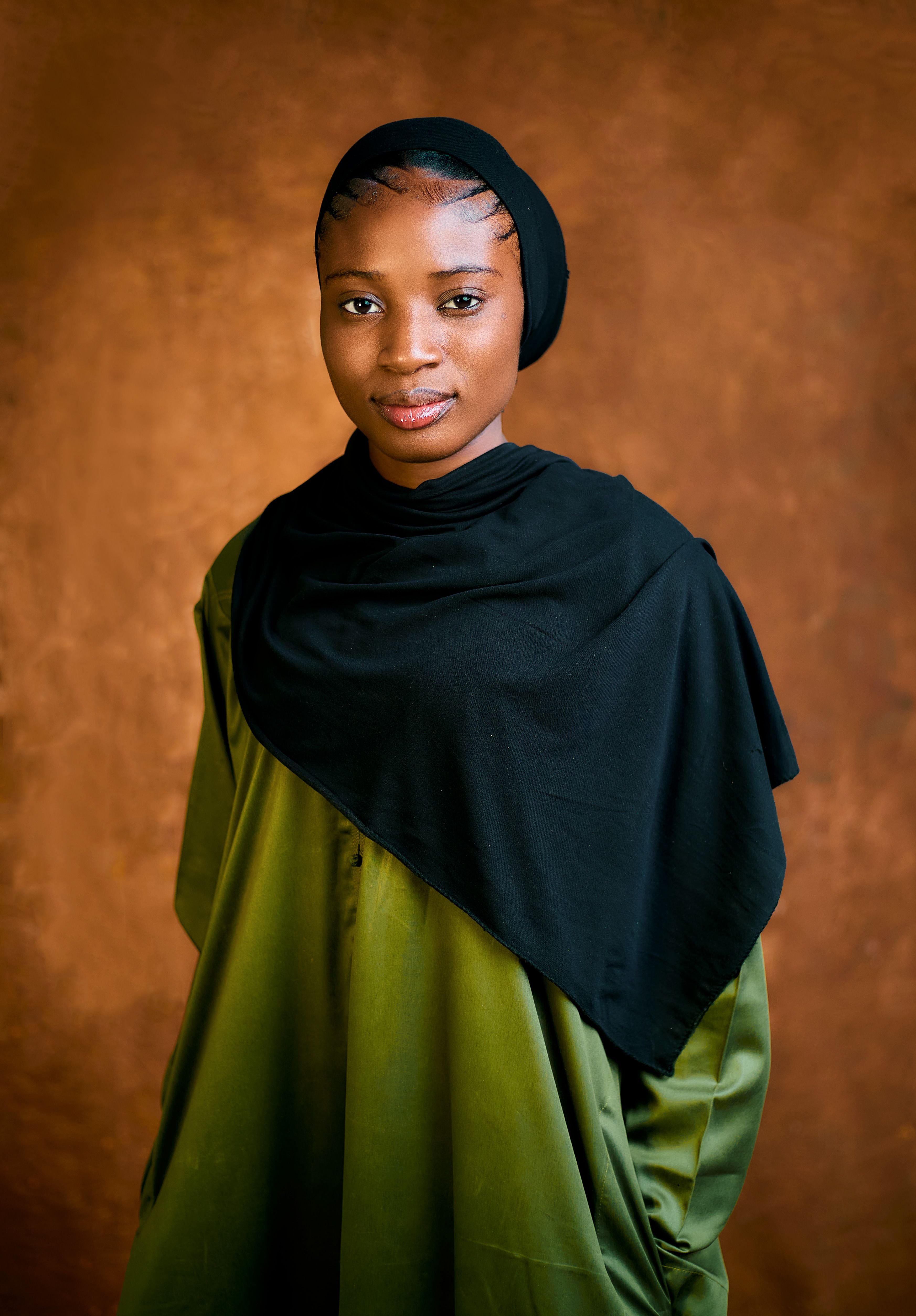 Portrait of a Young Woman in Hijab with Warm Backdrop · Free Stock Photo