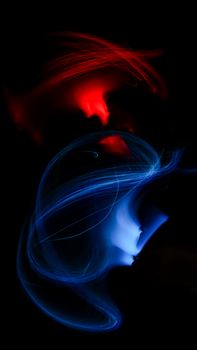 Dynamic abstract light streaks in vibrant red and blue against a dark background.