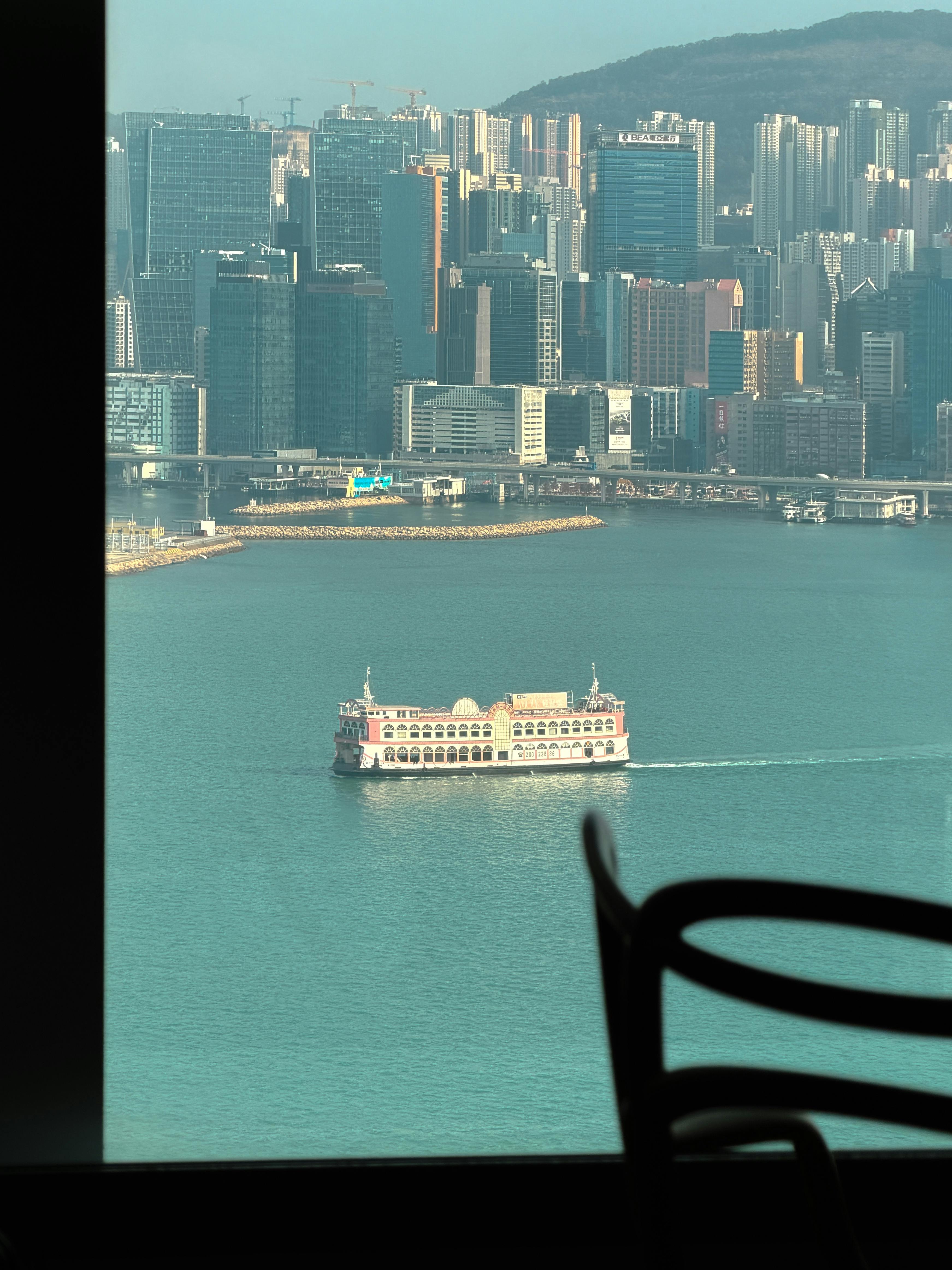 Δωρεάν Άποψη του ορίζοντα και του πορθμείου του Χονγκ Κονγκ μέσα από ένα πλαίσιο παραθύρου που απαθανατίζει την αστική ζωή. Φωτογραφία από στοκ φωτογραφιών