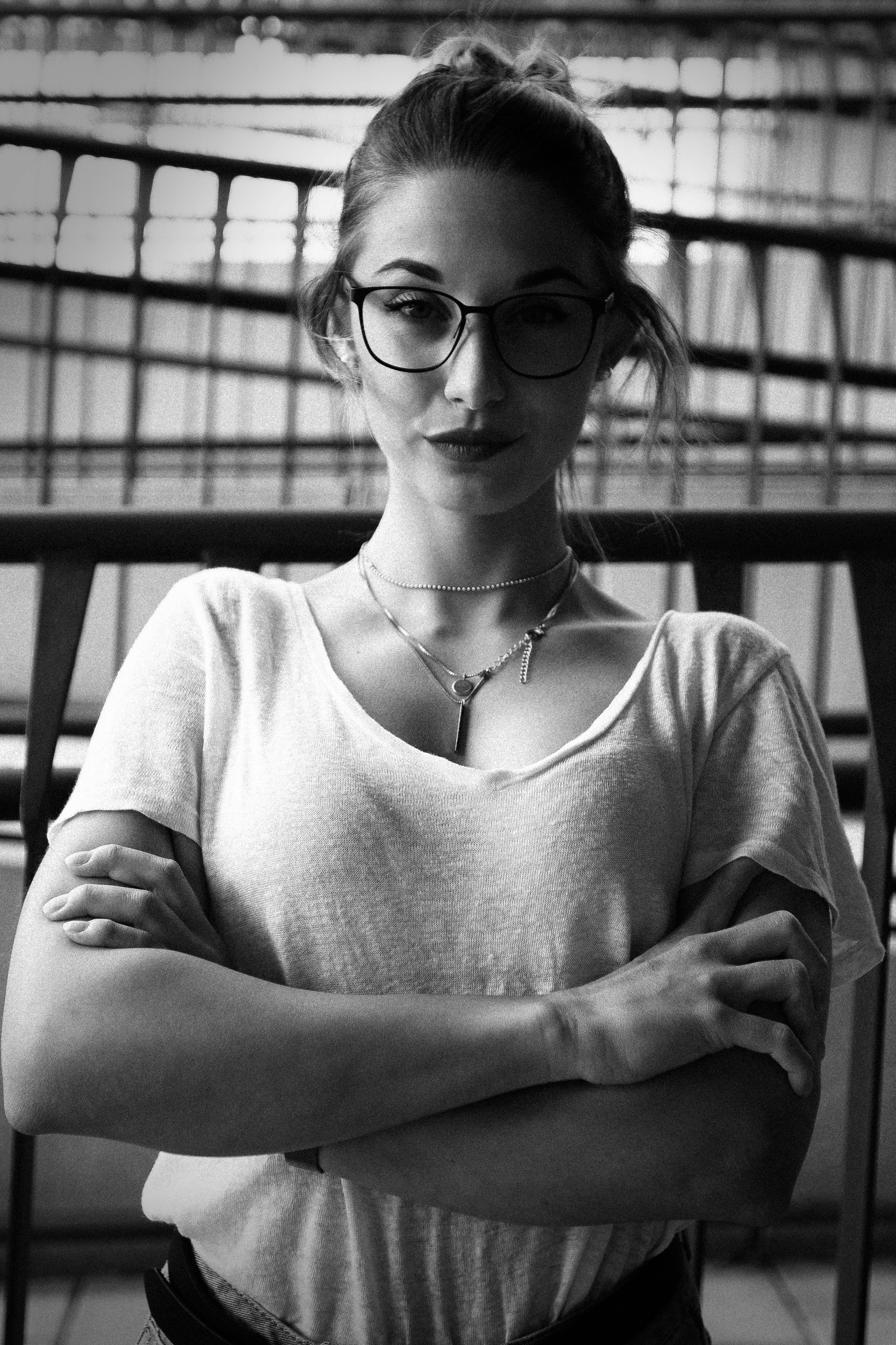 Δωρεάν Πορτρέτο μιας γυναίκας με αυτοπεποίθηση και γυαλιά που ποζάρει σε εσωτερικό χώρο σε ασπρόμαυρο. Φωτογραφία από στοκ φωτογραφιών