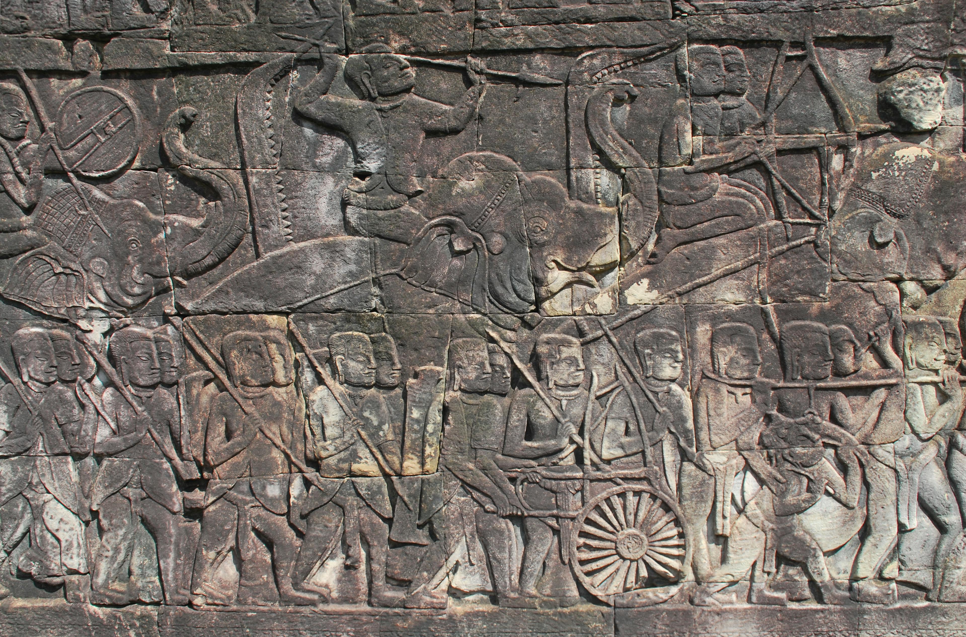 無料 カンボジアのアンコールワットの歴史的な場面を描いた精巧な古代の石の彫刻。 写真素材