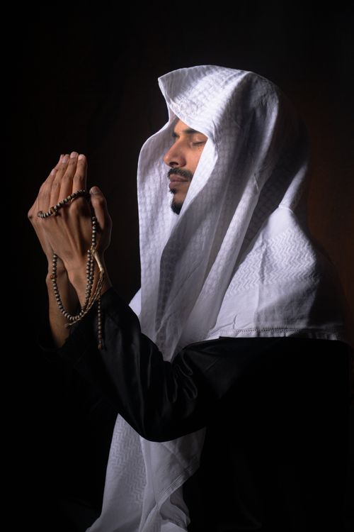 Man in Traditional Attire Holding Prayer Beads · Free Stock Photo