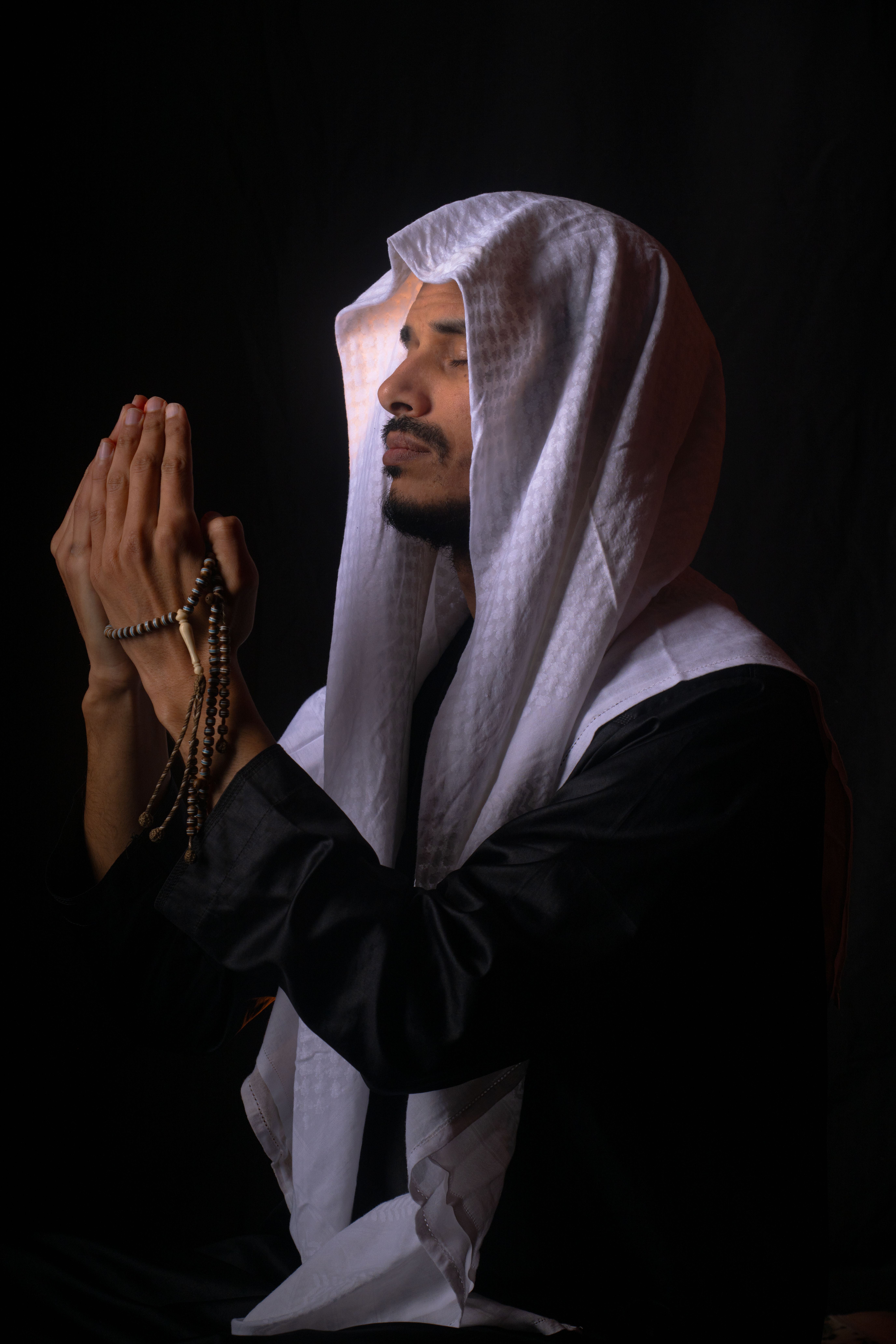 Man in Traditional Attire Holding Prayer Beads · Free Stock Photo