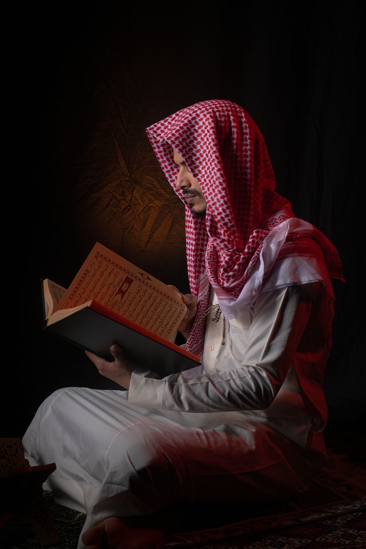 Man Praying with Rosary Beads in Traditional Attire · Free Stock Photo