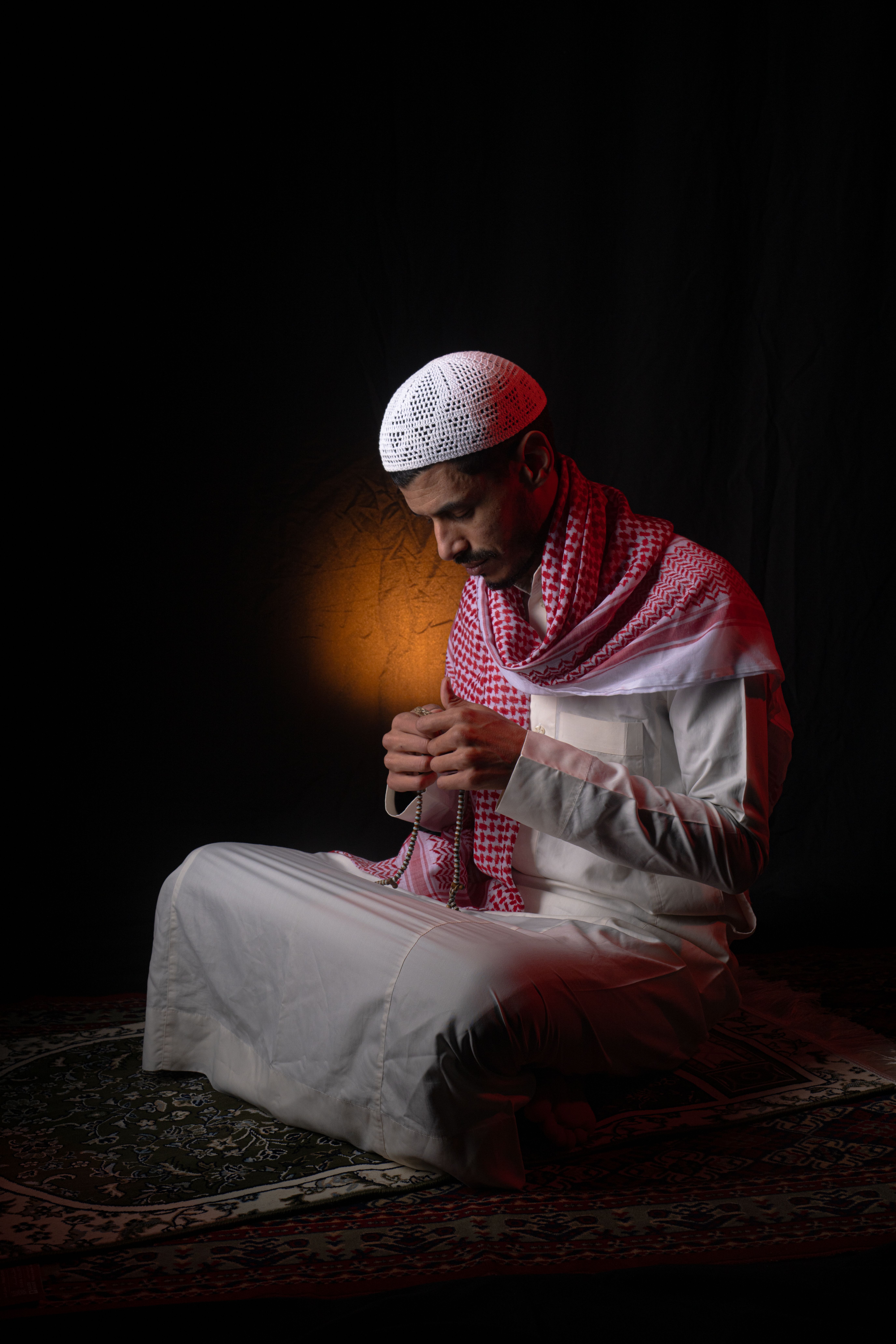 Devout Man Praying with Prayer Beads in Traditional Attire · Free Stock ...