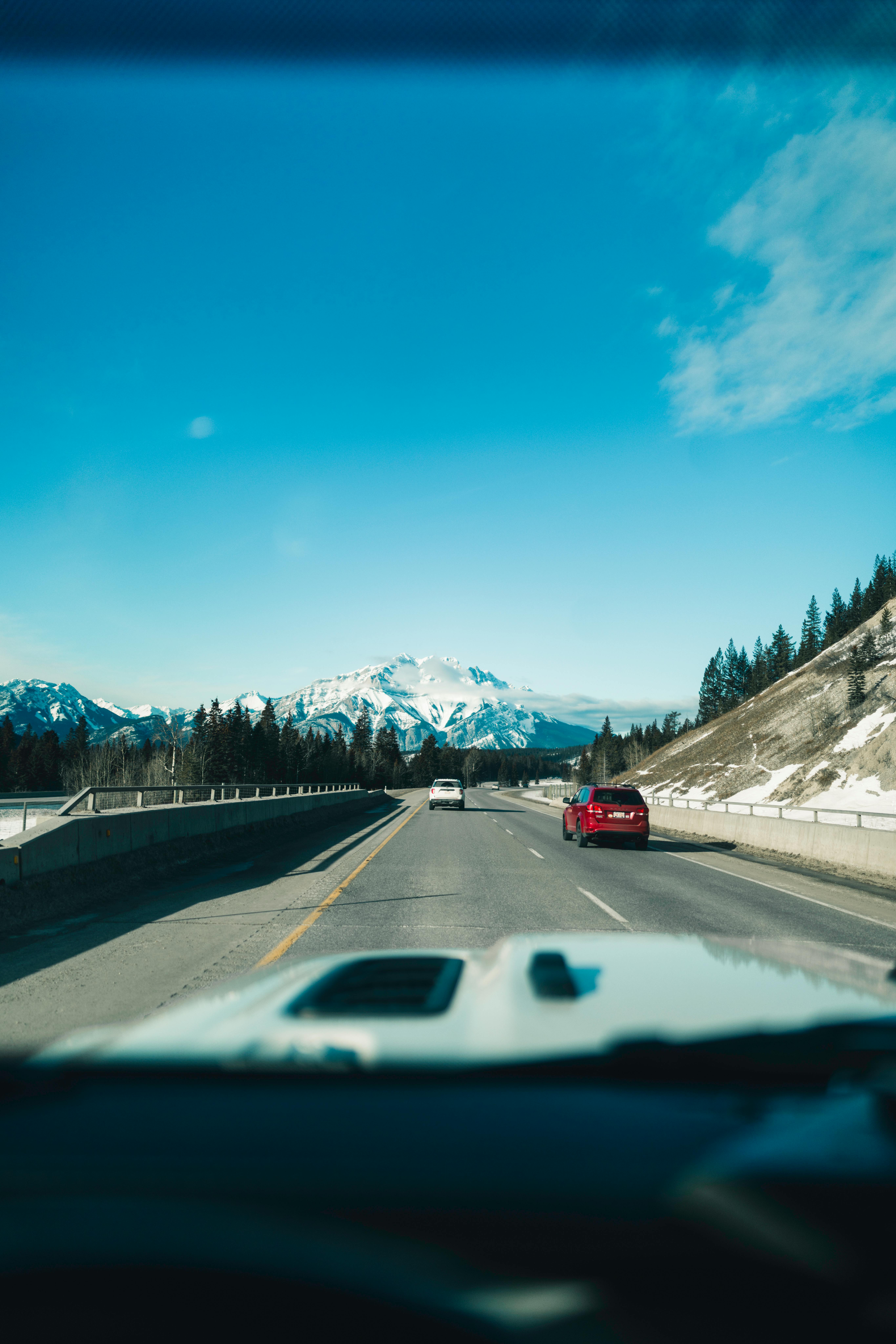 Kostenlos Erleben Sie eine atemberaubende Fahrt durch Banff mit fantastischen Bergpanoramen und strahlend blauem Himmel. Stock-Foto