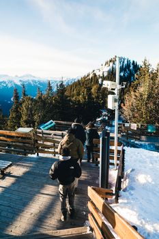 Hikers enjoy a winter trek along a snowy wooden path in Banff National Park, Canada.