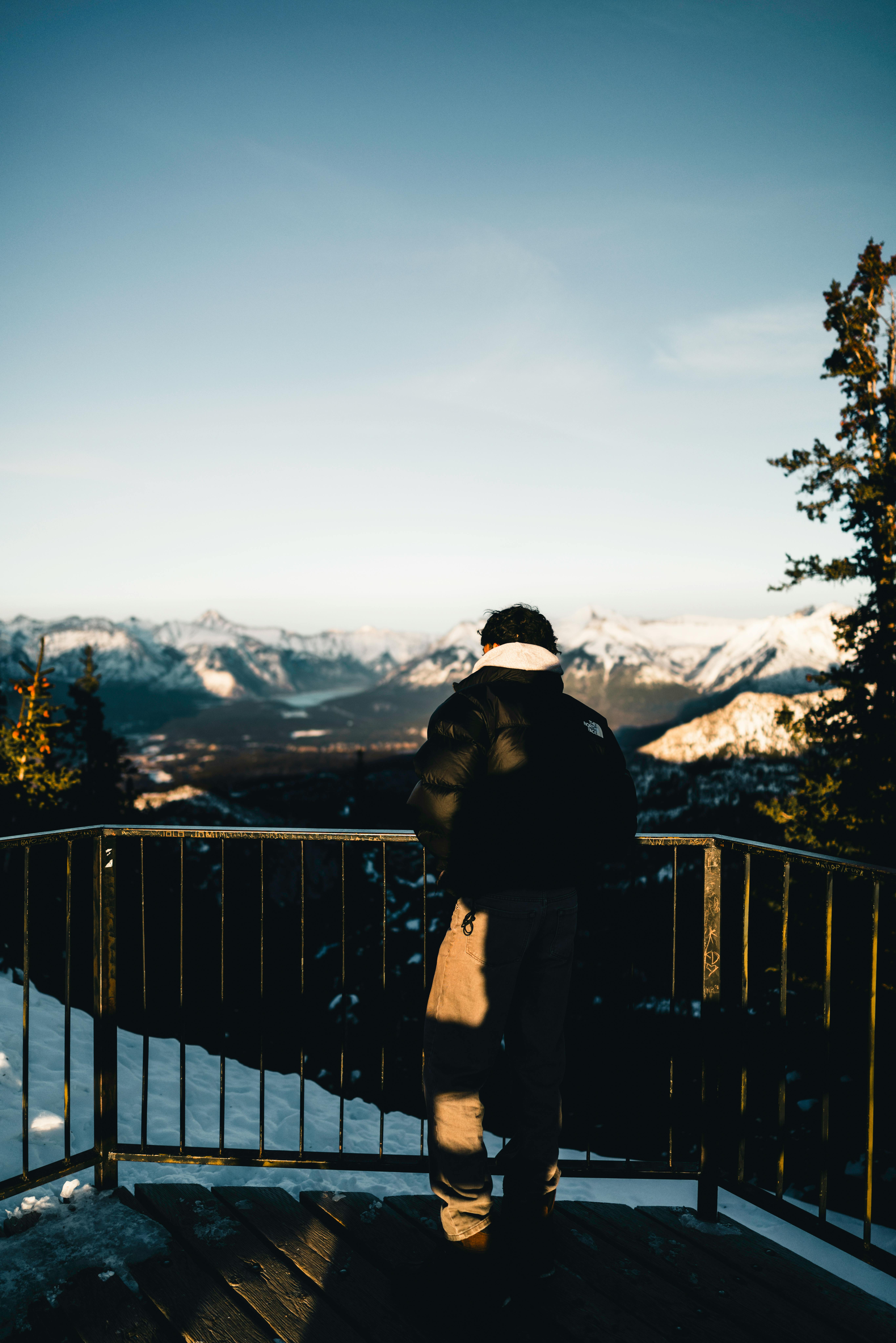 Kostenlos Eine Person bewundert den atemberaubenden Blick auf die schneebedeckten Berge von Banff bei Sonnenuntergang. Stock-Foto