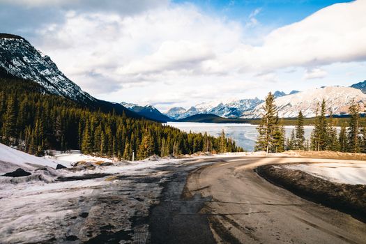 Captivating winter landscape in Banff National Park, highlighting snow-covered mountains and a winding road.