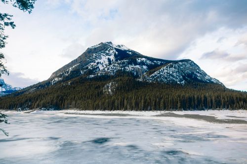 Free Stunning view of a snow-capped mountain and frozen lake in Banff National Park, Alberta. Stock Photo