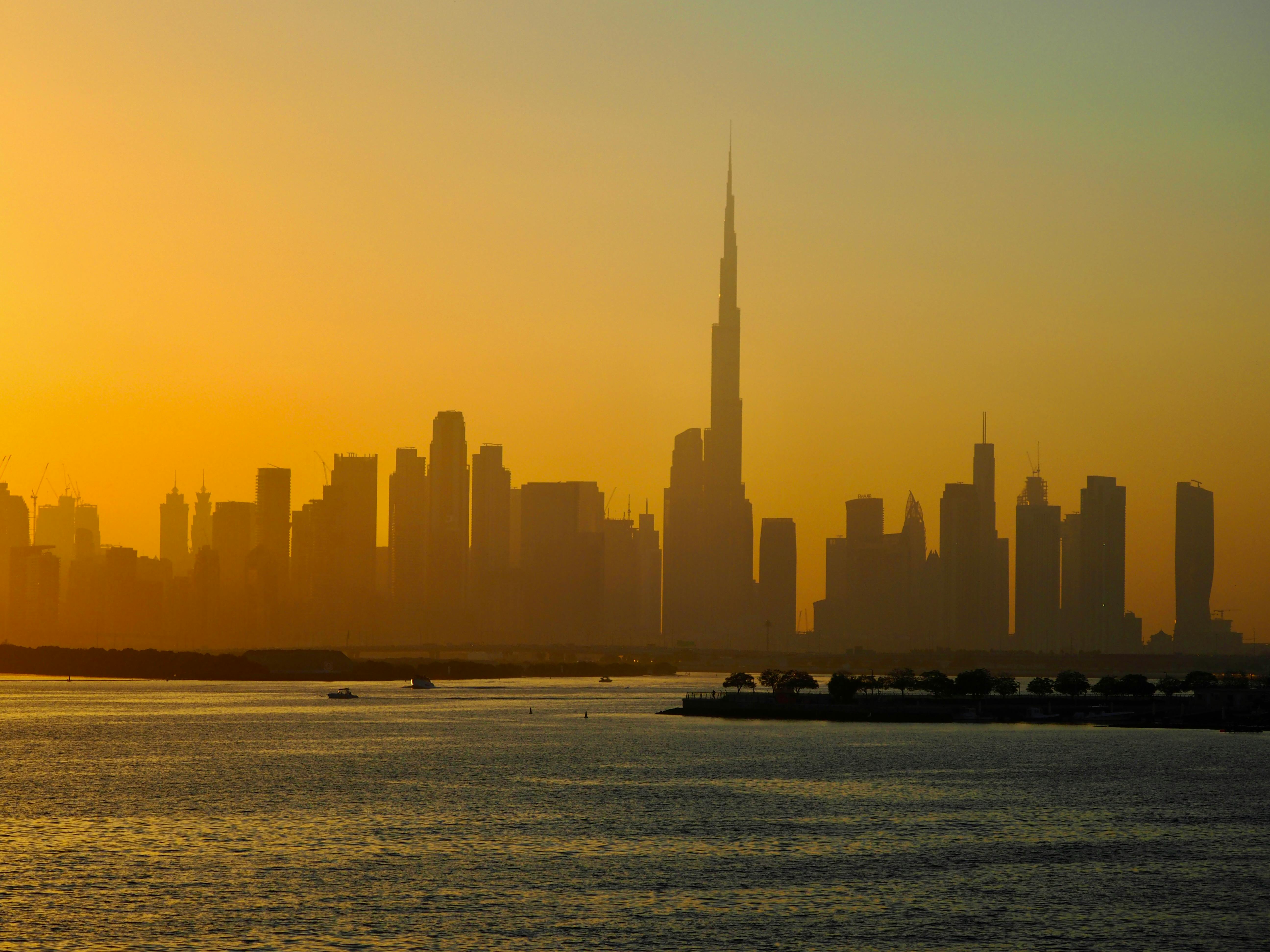Kostenlos Faszinierender Blick auf die Skyline von Dubai mit dem Burj Khalifa bei Sonnenuntergang, der urbane Modernität und architektonische Schönheit eindrucksvoll präsentiert. Stock-Foto