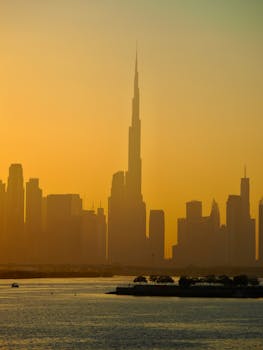 A stunning view of Dubai's skyline with the Burj Khalifa at sunset, reflecting on the water.