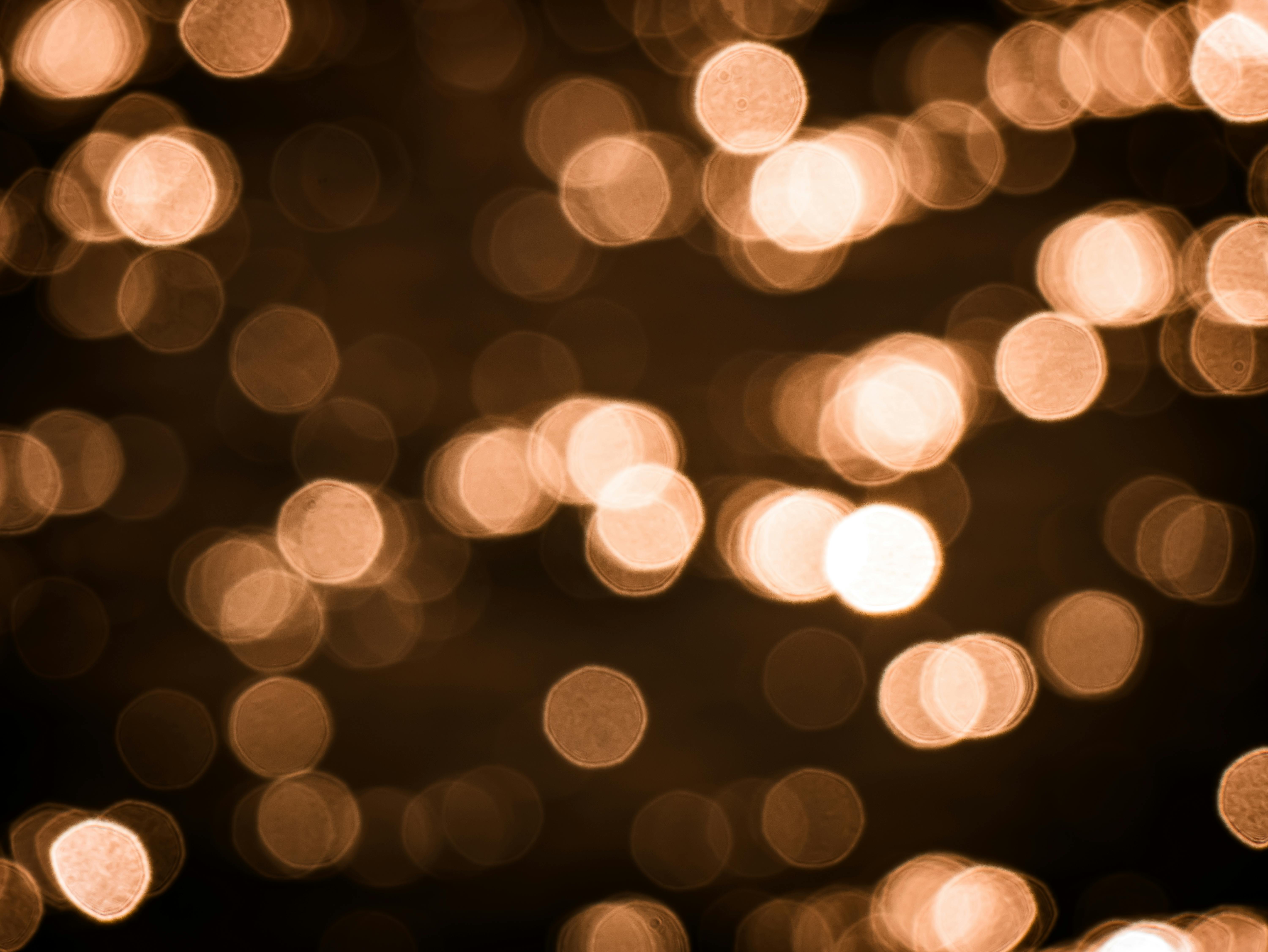 Free A mesmerizing abstract image featuring shimmering warm-toned bokeh lights. Stock Photo