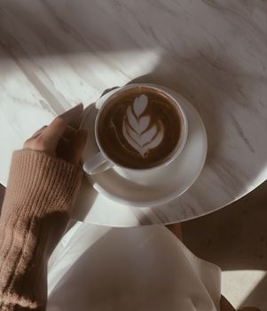 A cozy scene of a cappuccino with latte art in a warm setting.