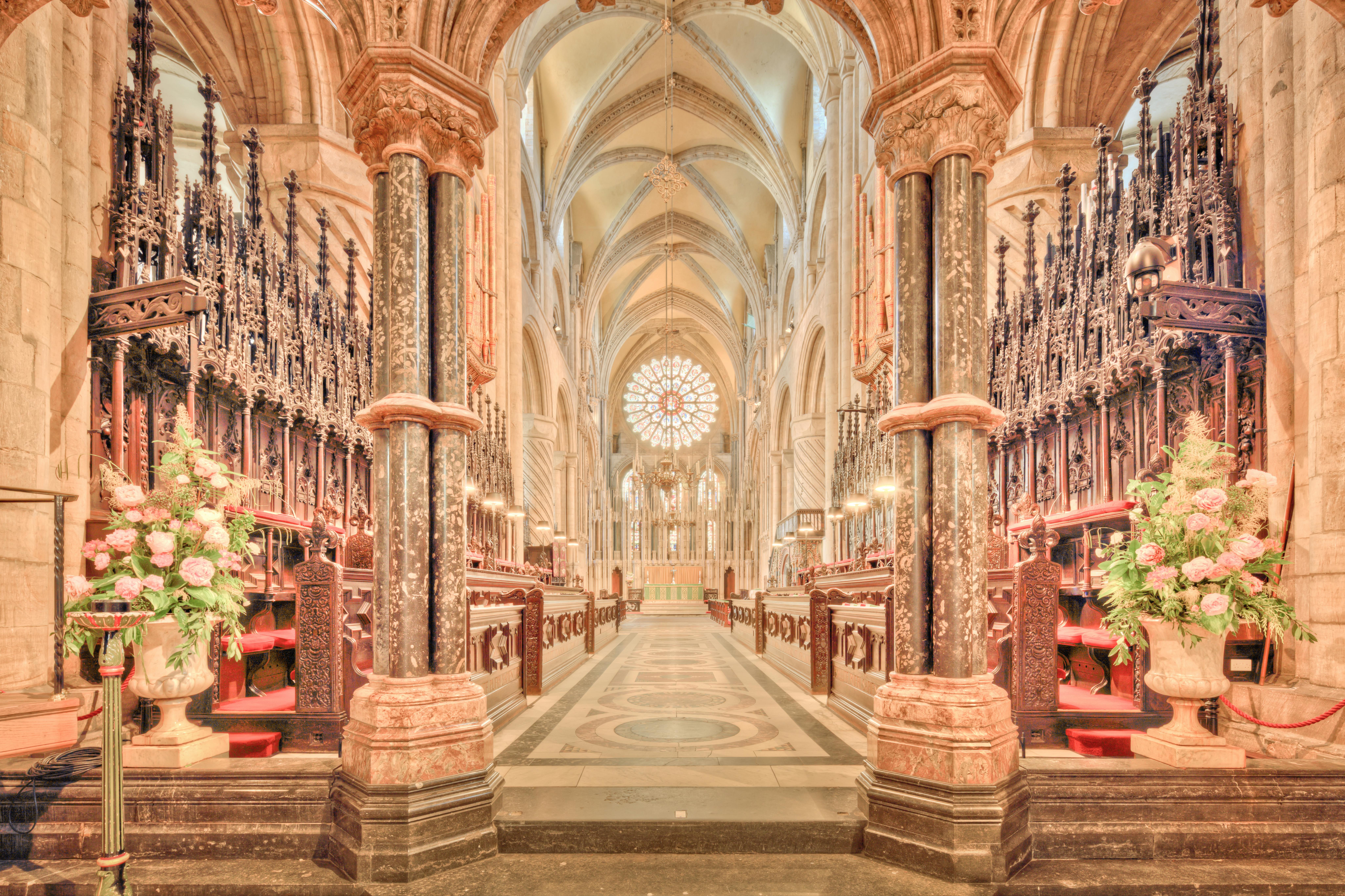 бесплатная Завораживающий вид на неф исторического Даремского собора с готическими арками и богато украшенными хорами. Стоковое фото