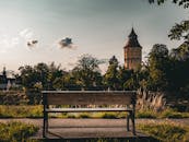 Landscape with Bench and Tower Under Cloudy Sky