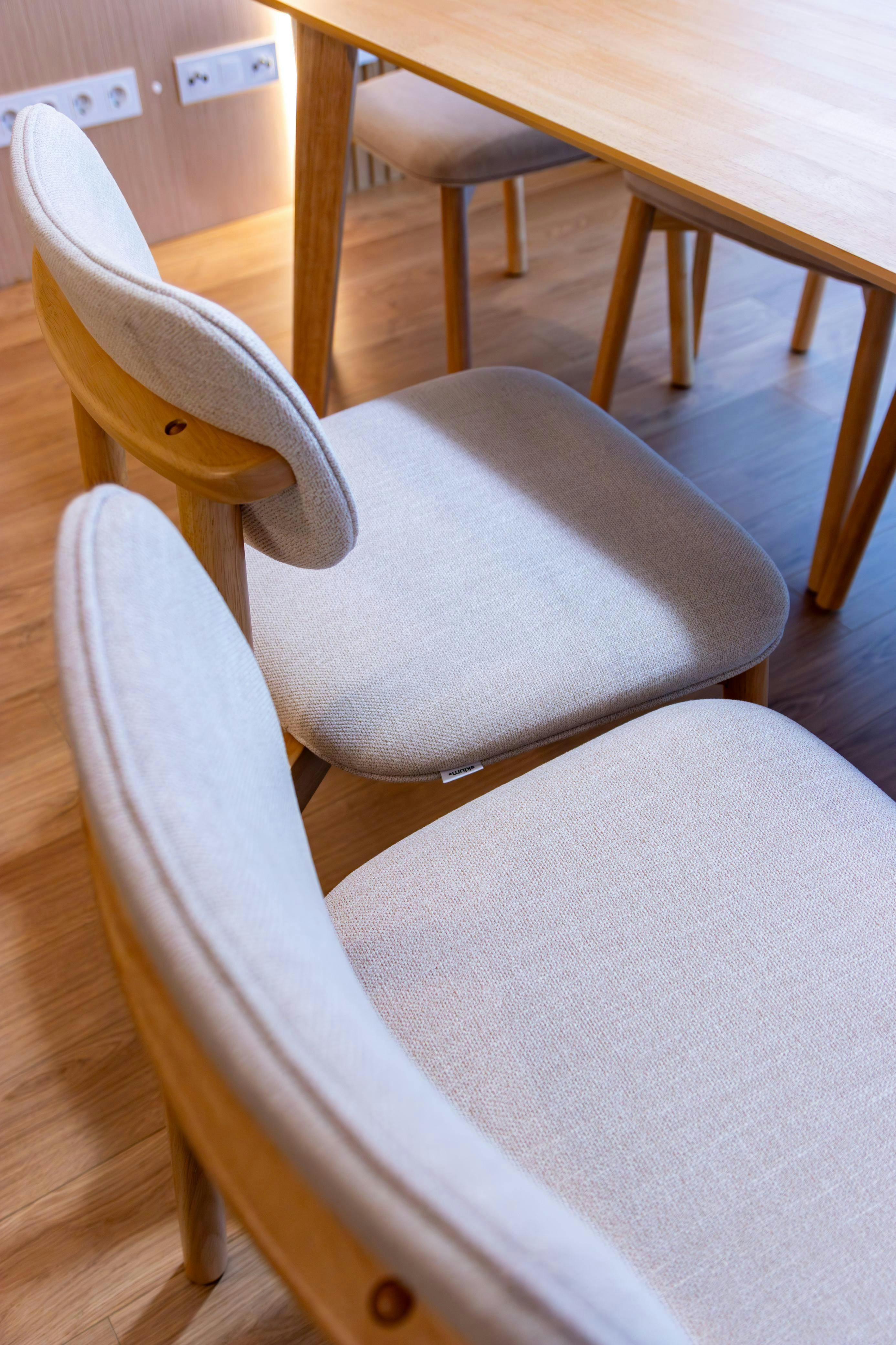 Δωρεάν Κομψές σκανδιναβικές καρέκλες τραπεζαρίας με ξύλινες λεπτομέρειες σε ένα φωτεινό εσωτερικό περιβάλλον. Φωτογραφία από στοκ φωτογραφιών