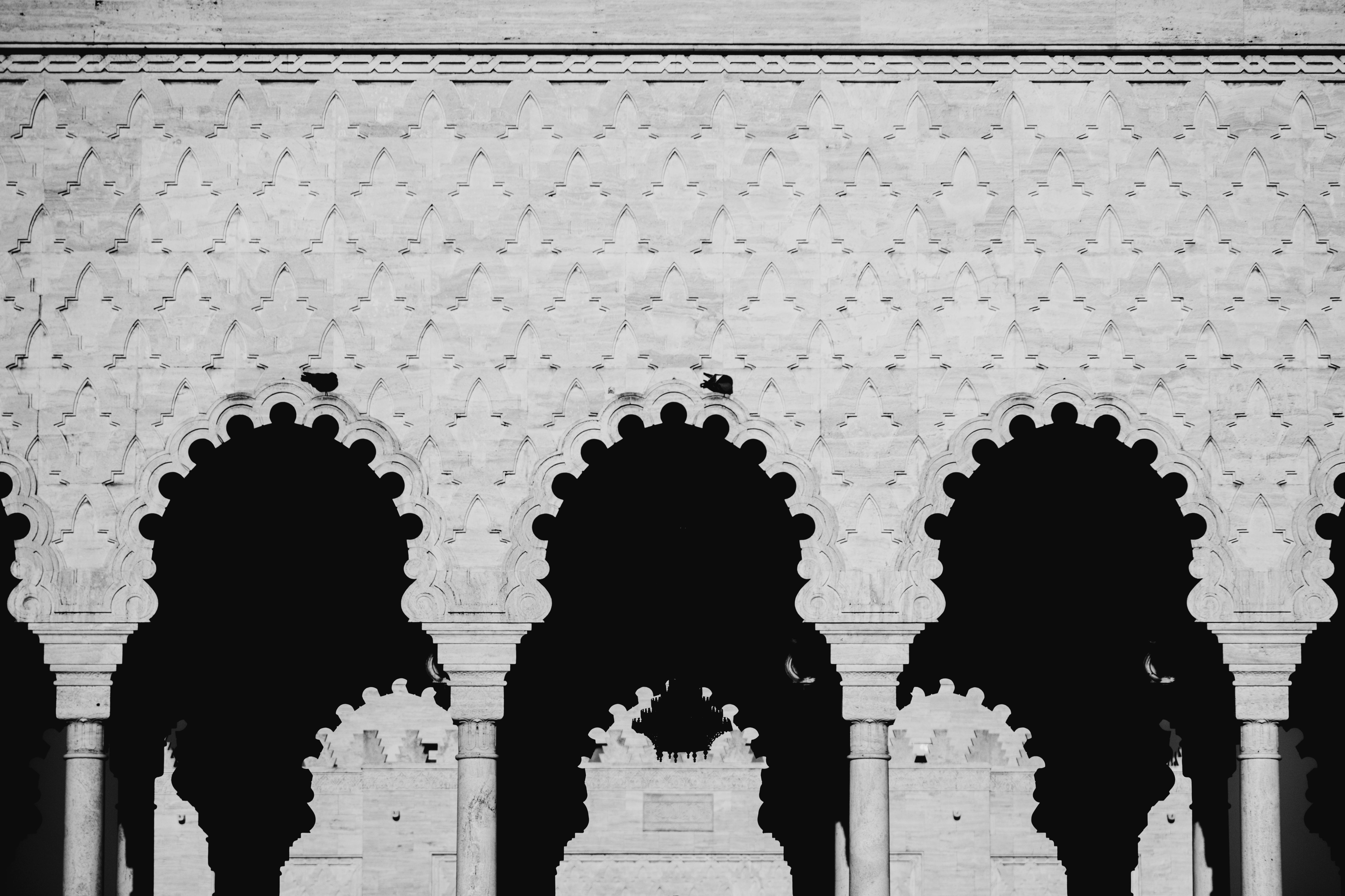 бесплатная Завораживающие мавританские арки с детальными узорами в монохромной гамме. Стоковое фото