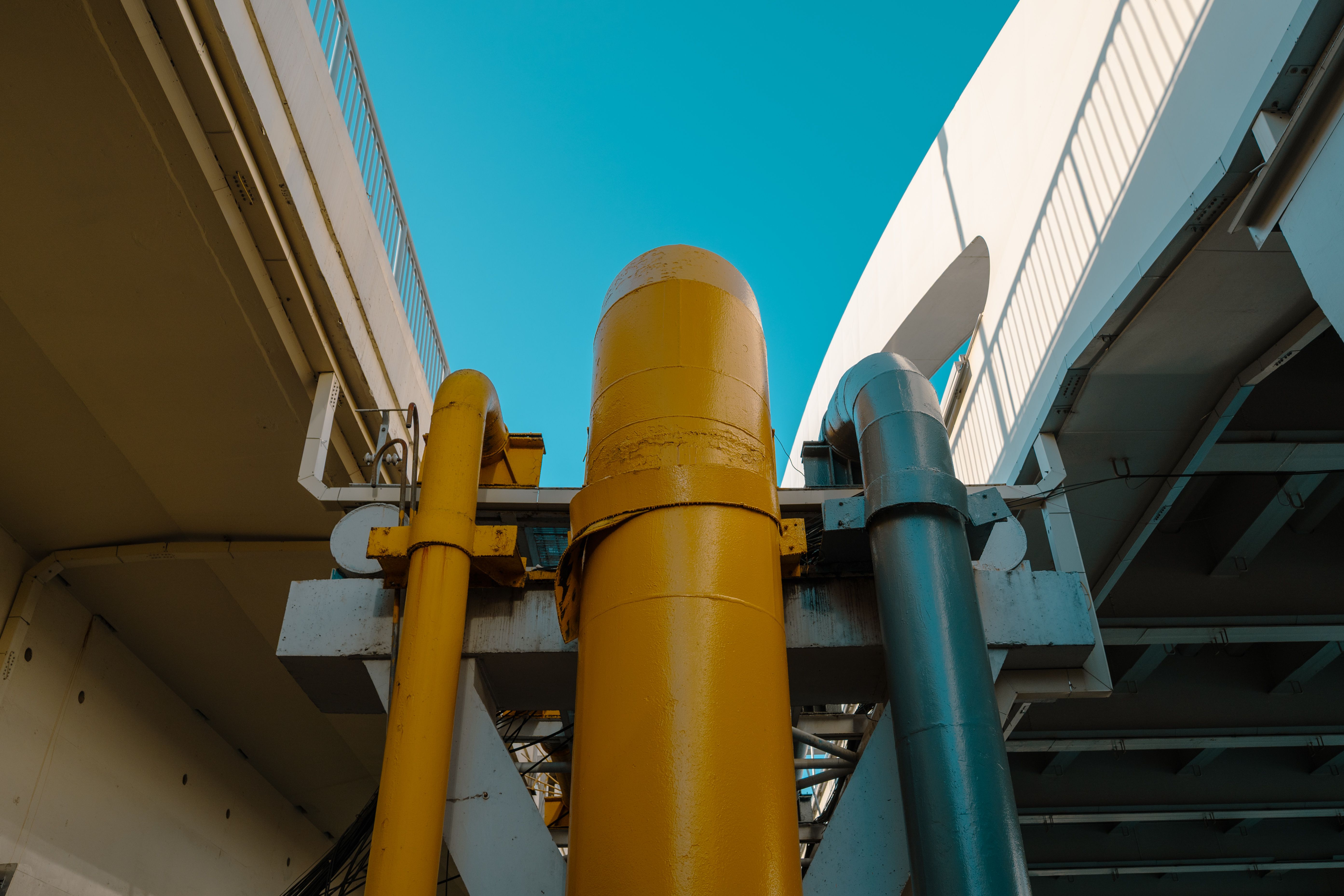 Industrial pipes under clear blue sky · Free Stock Photo