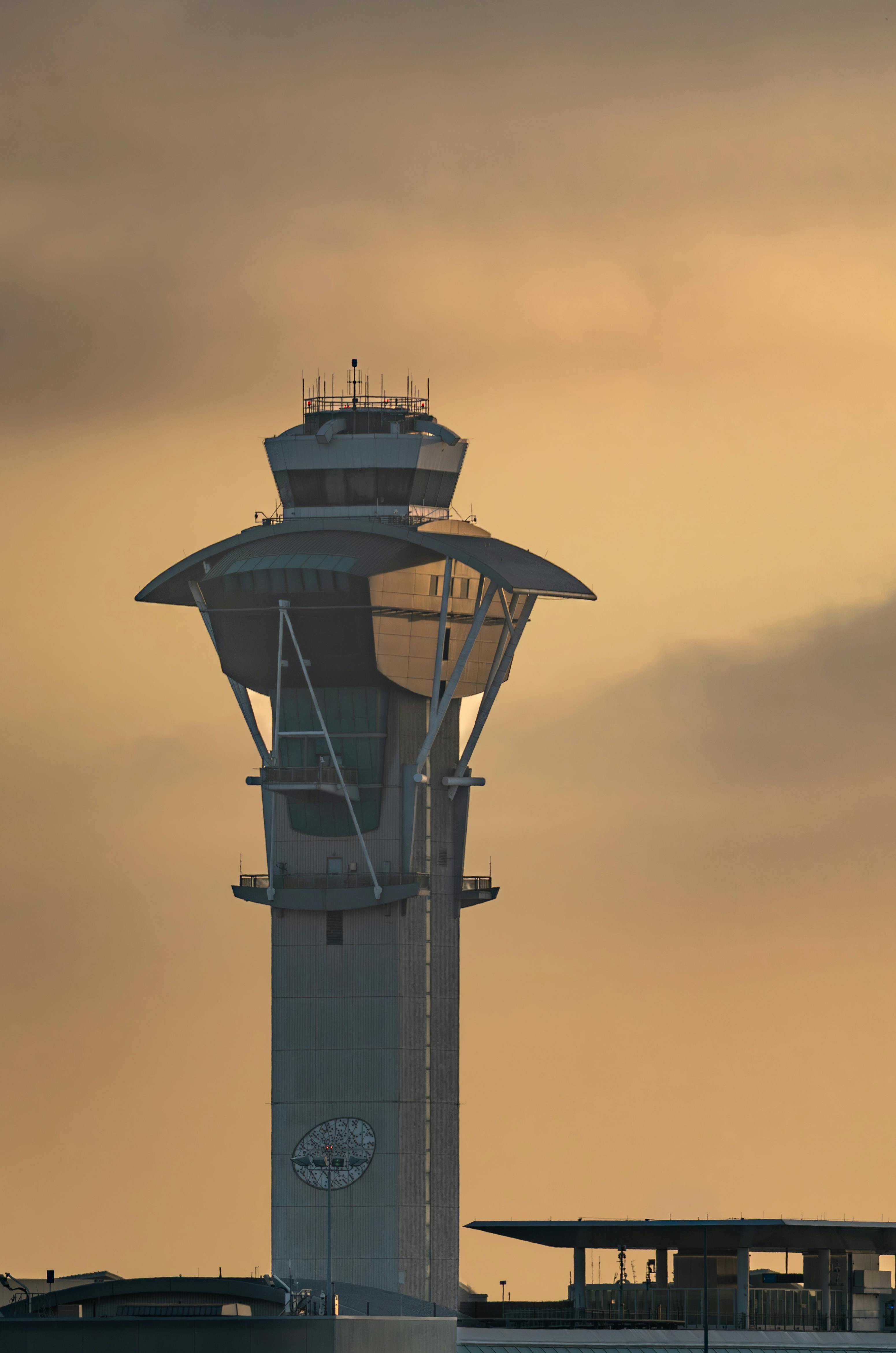 Kostenlos Ein beeindruckender Anblick: Der Kontrollturm des Flughafens von Los Angeles zeichnet sich als Silhouette vor einem atemberaubenden Sonnenuntergangshimmel ab. Stock-Foto
