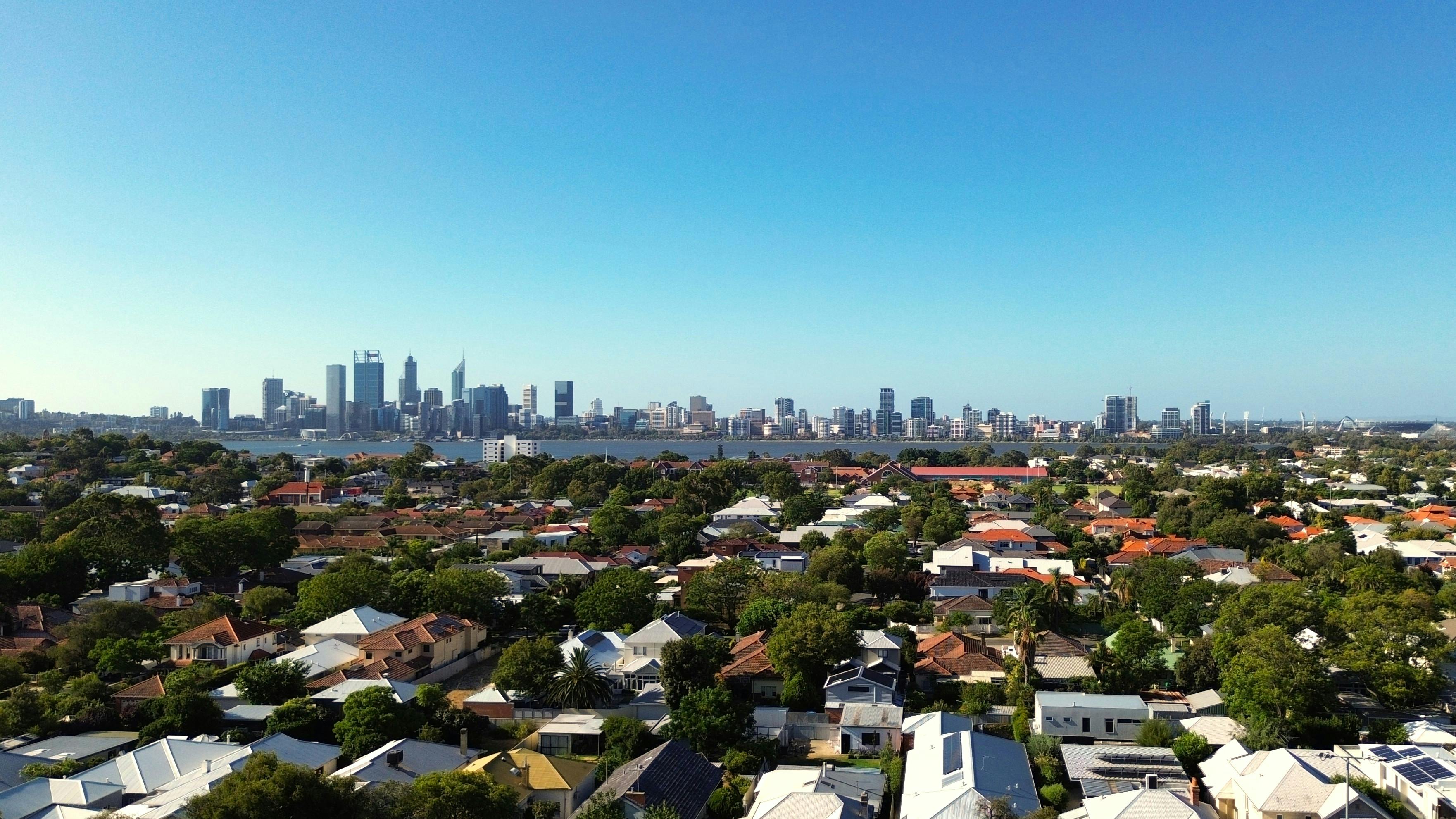 Kostenlos Atemberaubende Luftaufnahme der Skyline von Perth und der Vorstadthäuser unter strahlend blauem Himmel. Stock-Foto