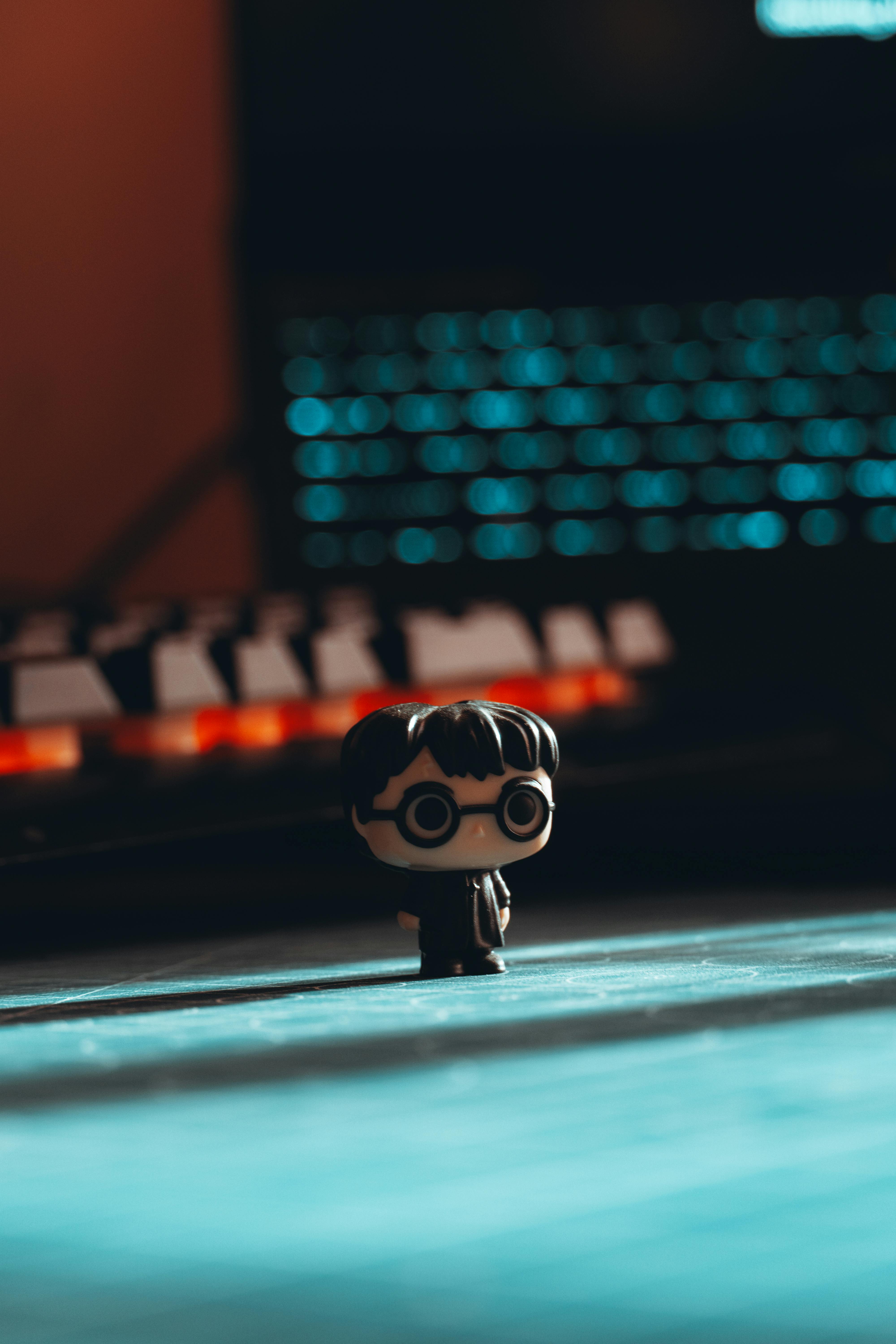 Free Vibrant Harry Potter figure on a desk with luminous keyboard background, perfect for decor or collector's item inspiration. Stock Photo