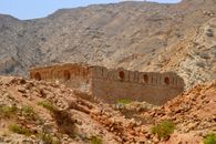 Explore the rustic charm of an ancient stone fort set in the desert hills of Muscat, Oman.