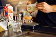 Bartender Pouring Juice into Glass at Bar