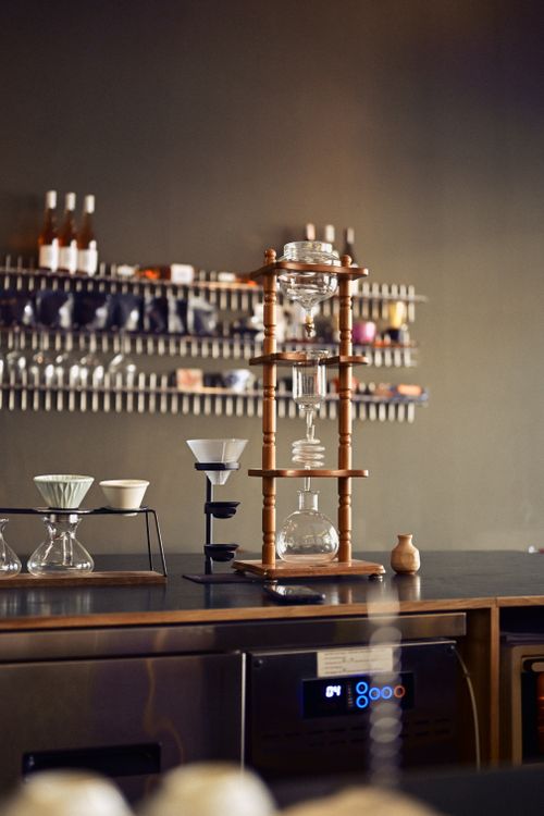 Free Stylish modern coffee bar featuring a wooden cold brew tower and various brewing tools. Stock Photo