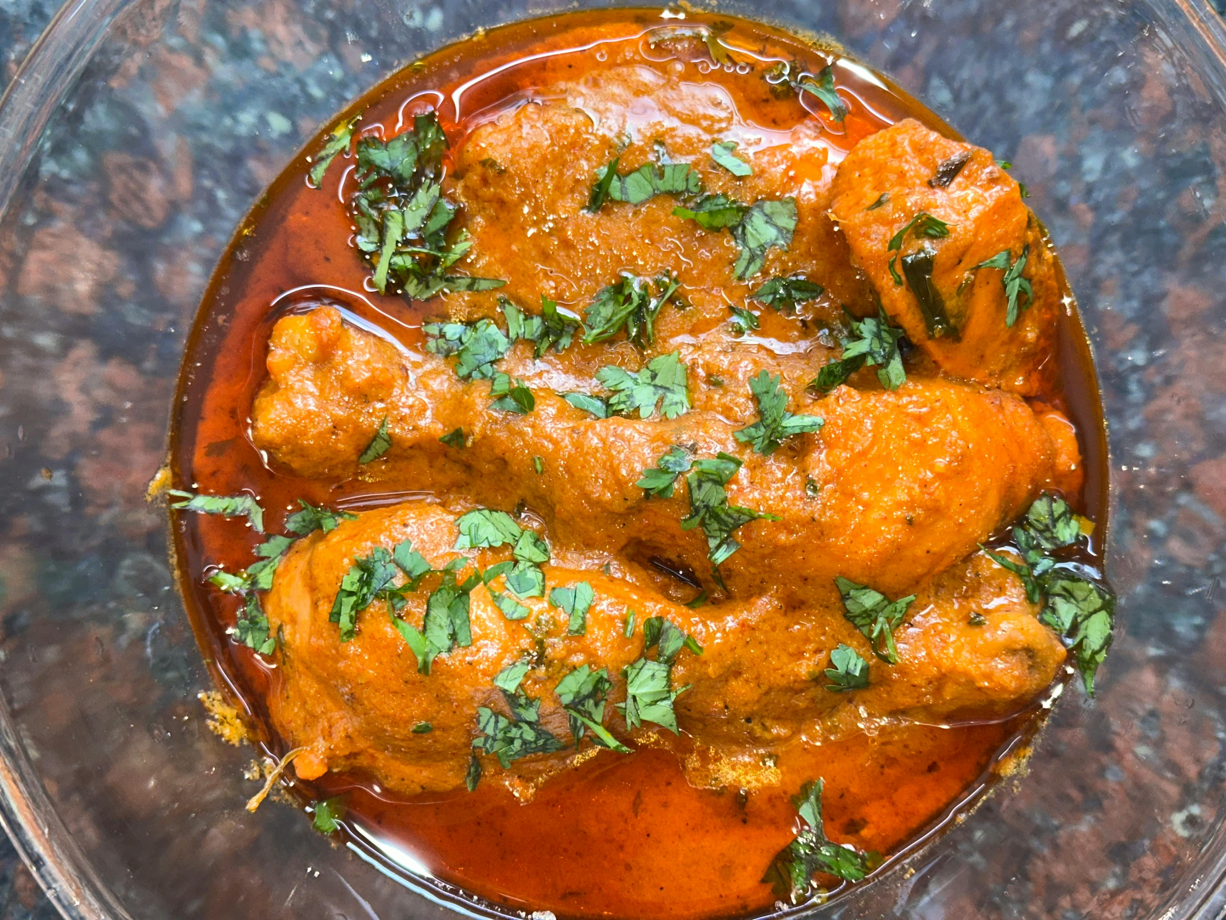 Kostenlos Nahaufnahme eines würzigen Hühnercurrygerichts mit frischem Koriander – perfekt für Liebhaber der indischen Küche. Stock-Foto