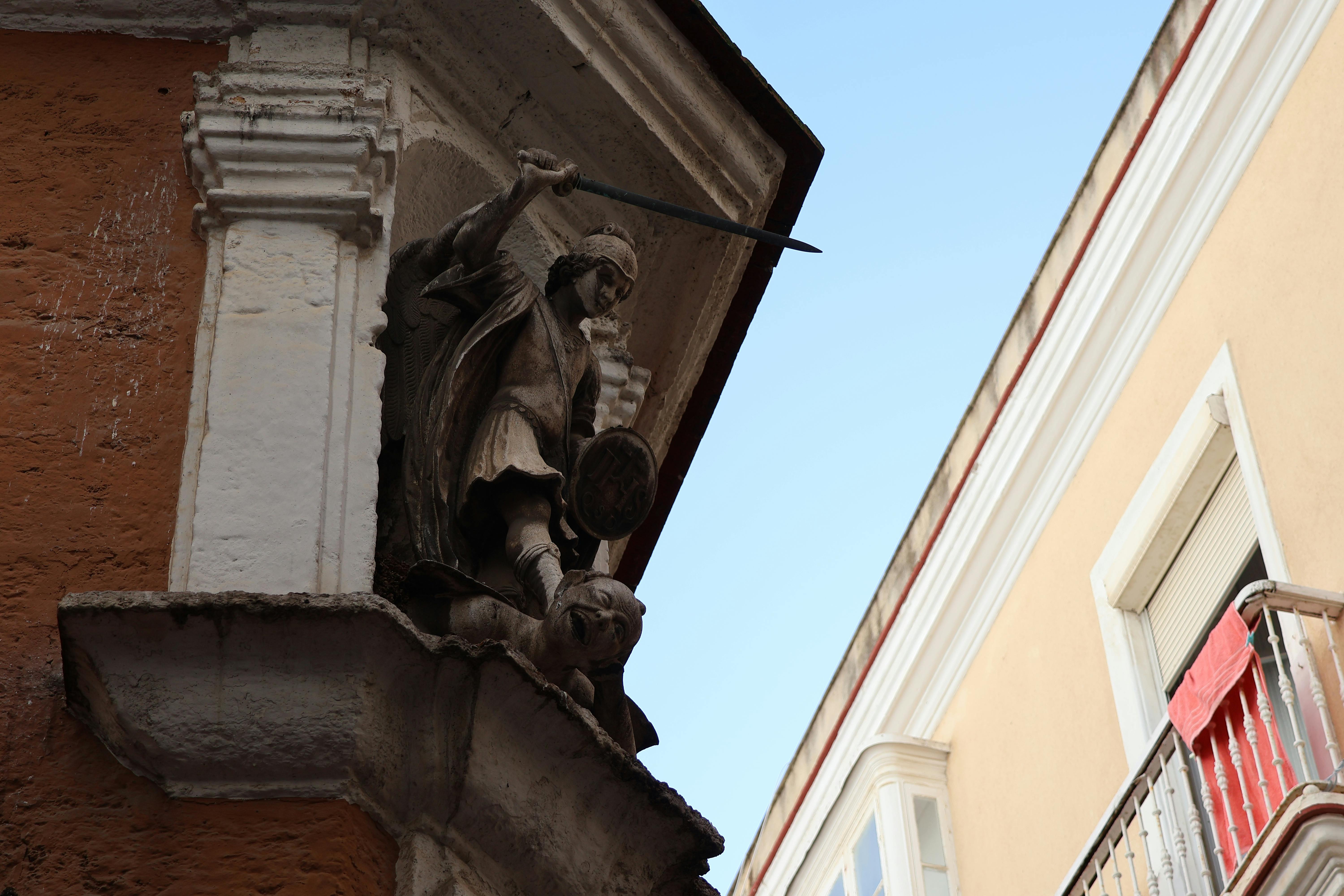 無料 スペインのカディスにある建物の正面には、聖ミカエルの精巧な彫刻が飾られています。 写真素材