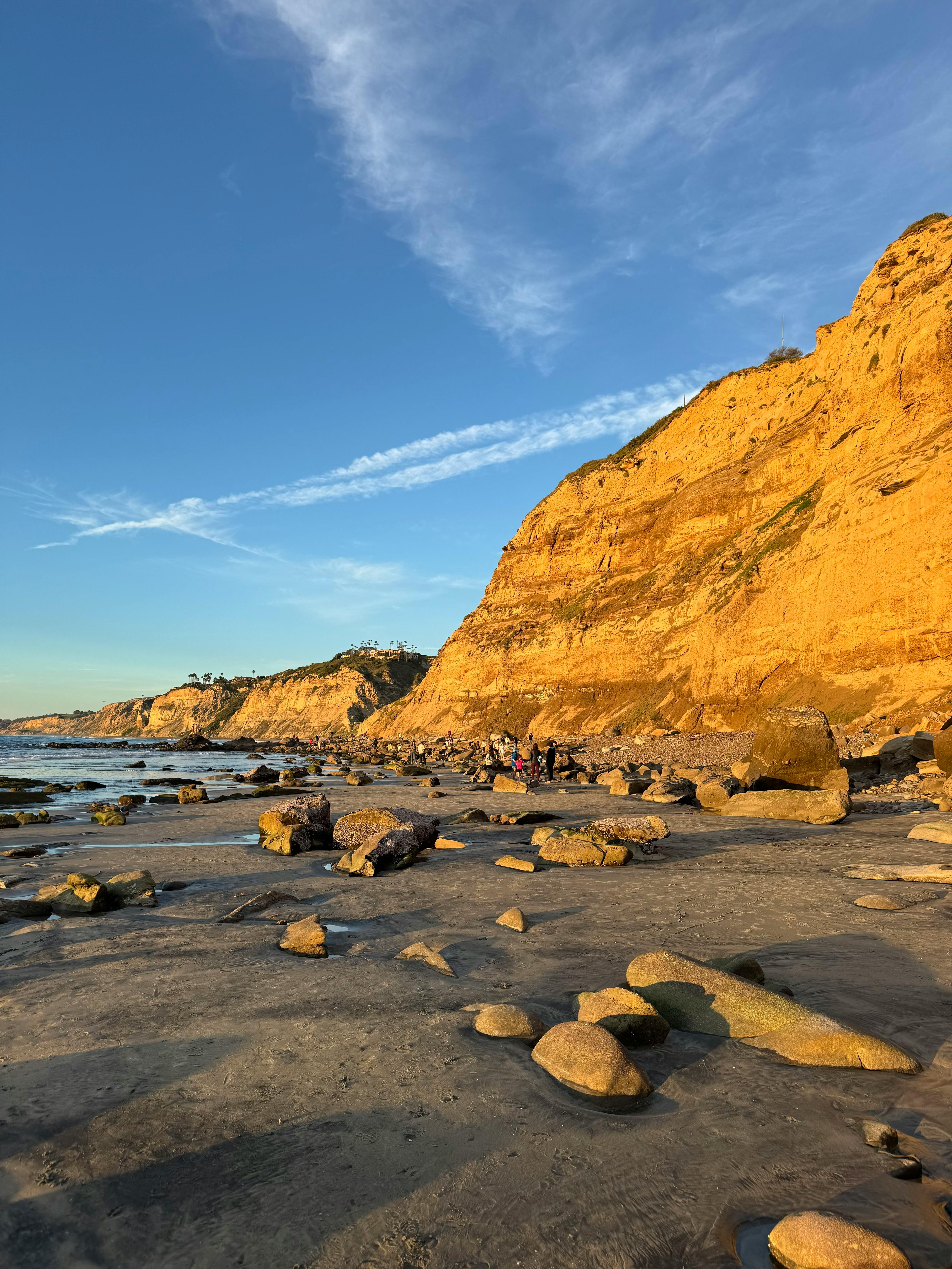 Stunning golden cliffs and rocky shoreline lit by sunset in San Diego, California.
