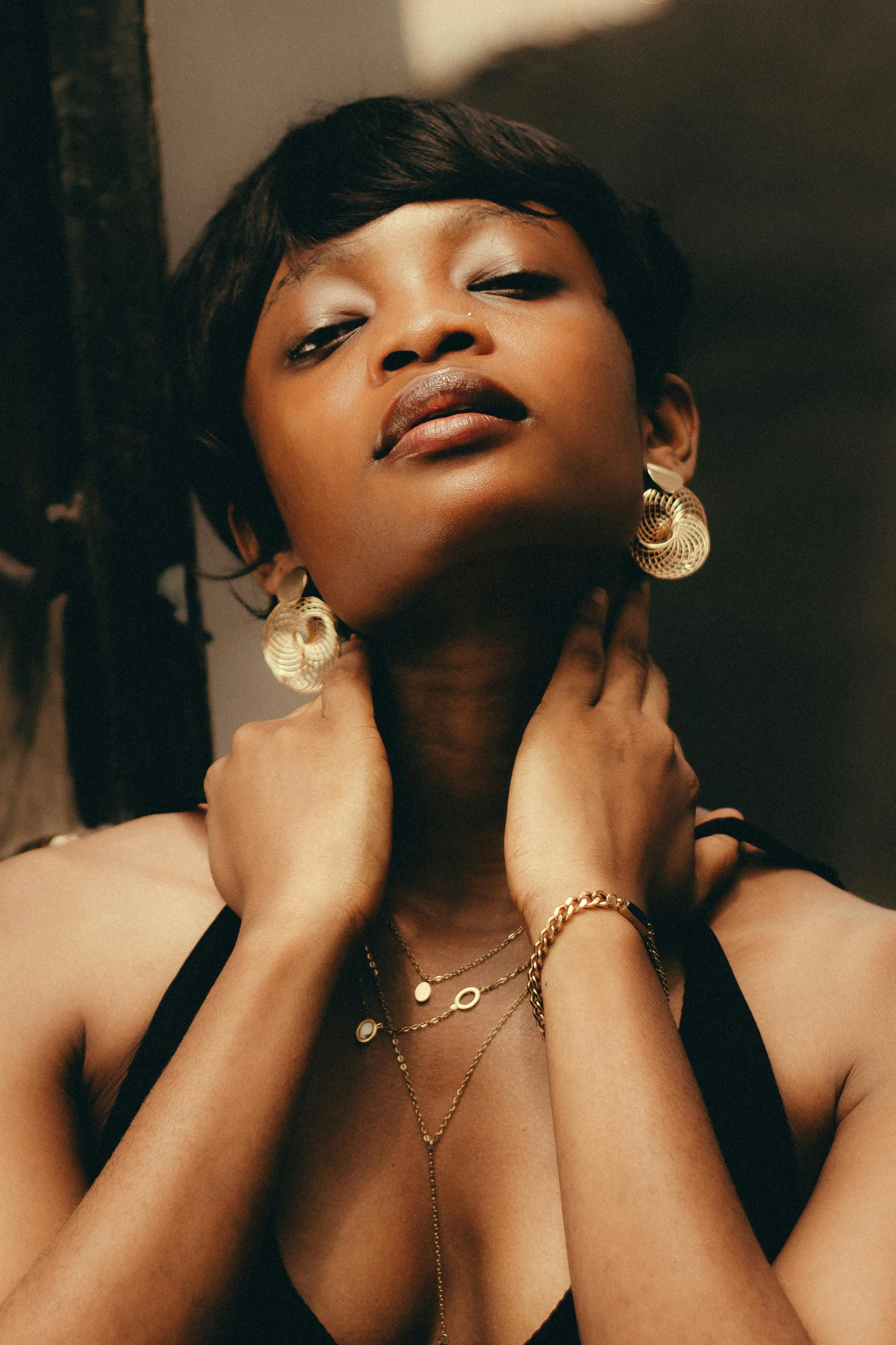 Kostenlos Elegantes Porträt einer Frau mit Goldschmuck, die einen raffinierten Modestil verkörpert. Stock-Foto