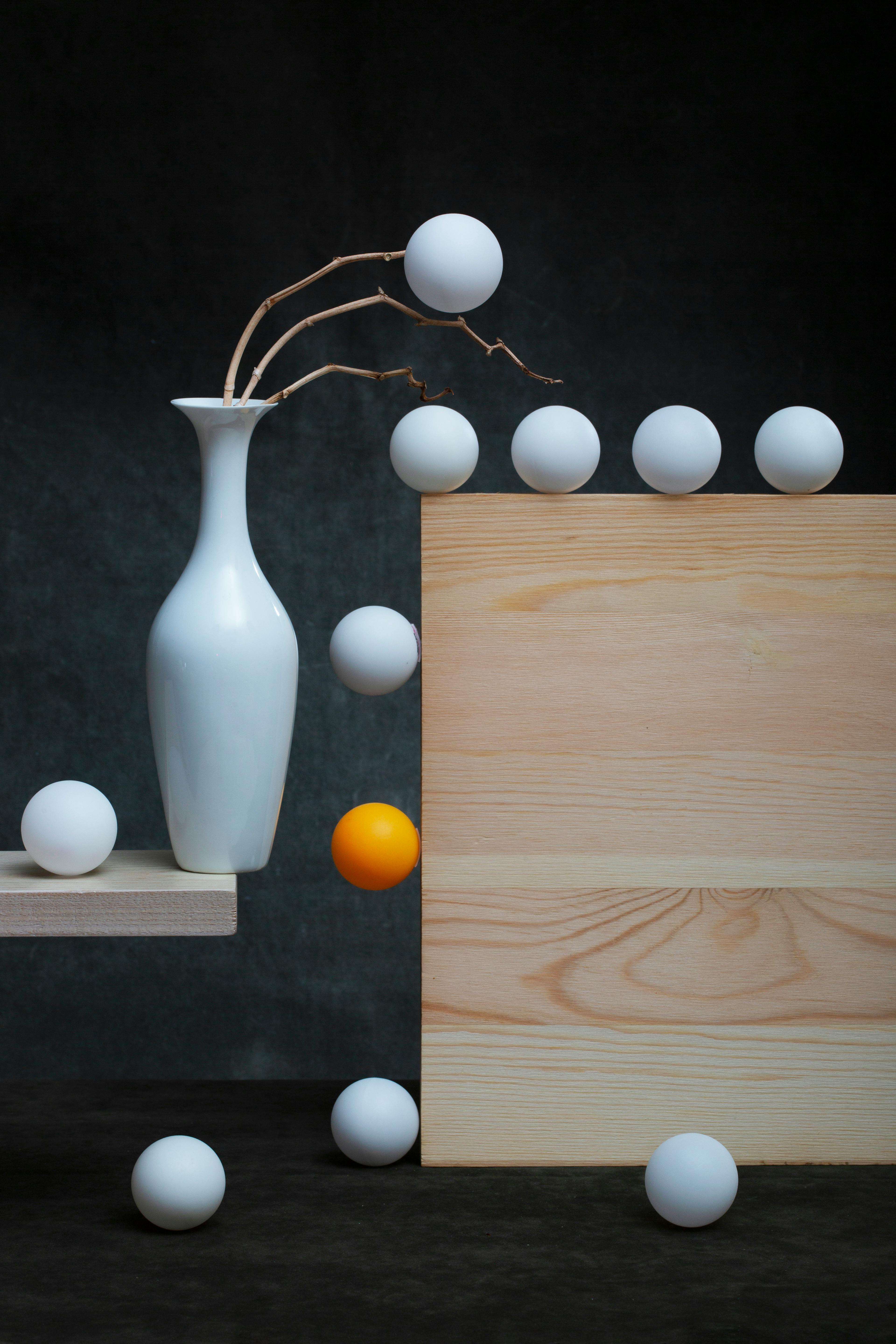 Δωρεάν Καλλιτεχνική νεκρή φύση με ένα λευκό βάζο, μπαλάκια του πινγκ πονγκ και ξύλινα στοιχεία σε περιβάλλον στούντιο. Φωτογραφία από στοκ φωτογραφιών