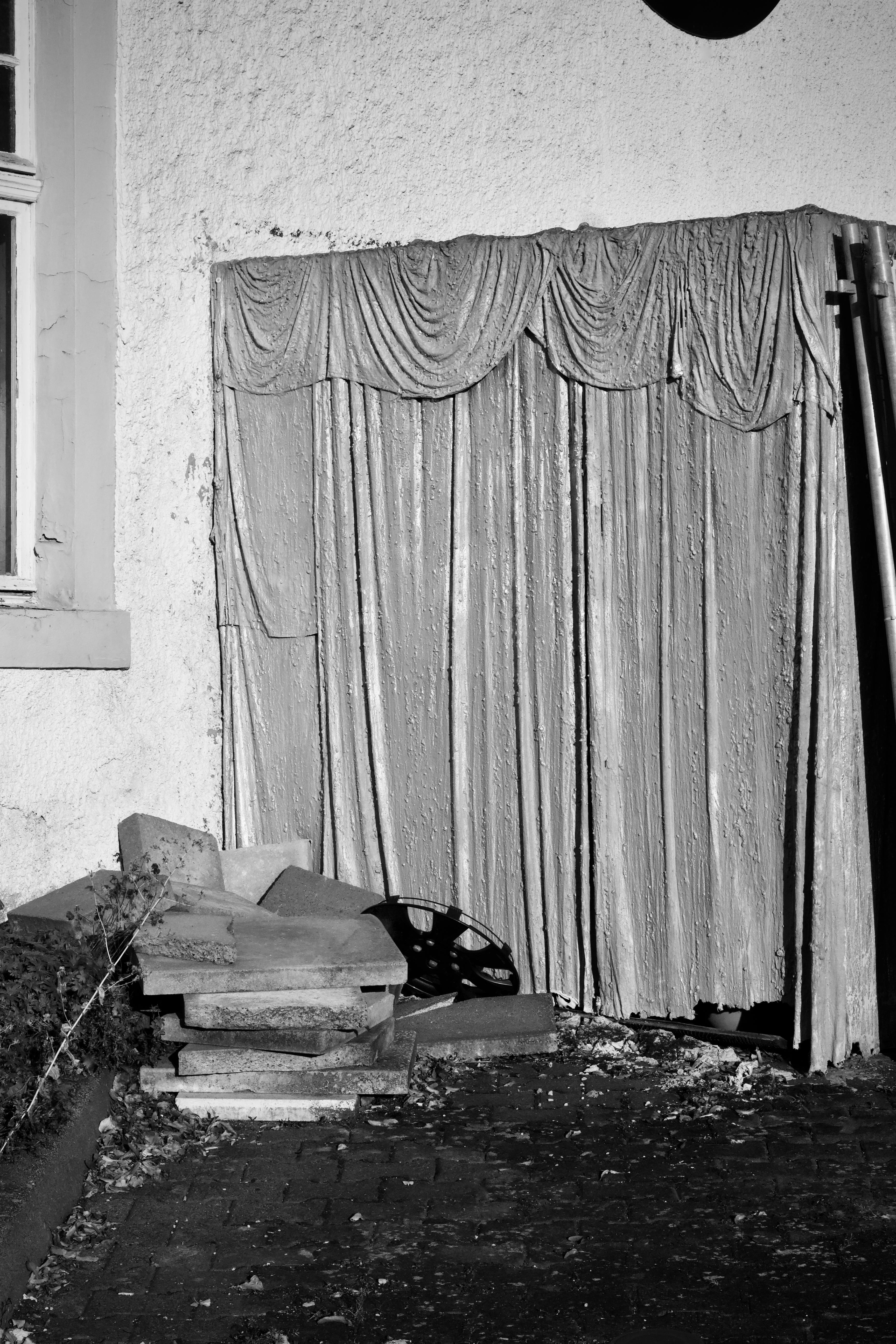 Δωρεάν Ασπρόμαυρη φωτογραφία ενός παραμελημένου εξωτερικού κτιρίου με σκισμένη κουρτίνα και συντρίμμια. Φωτογραφία από στοκ φωτογραφιών