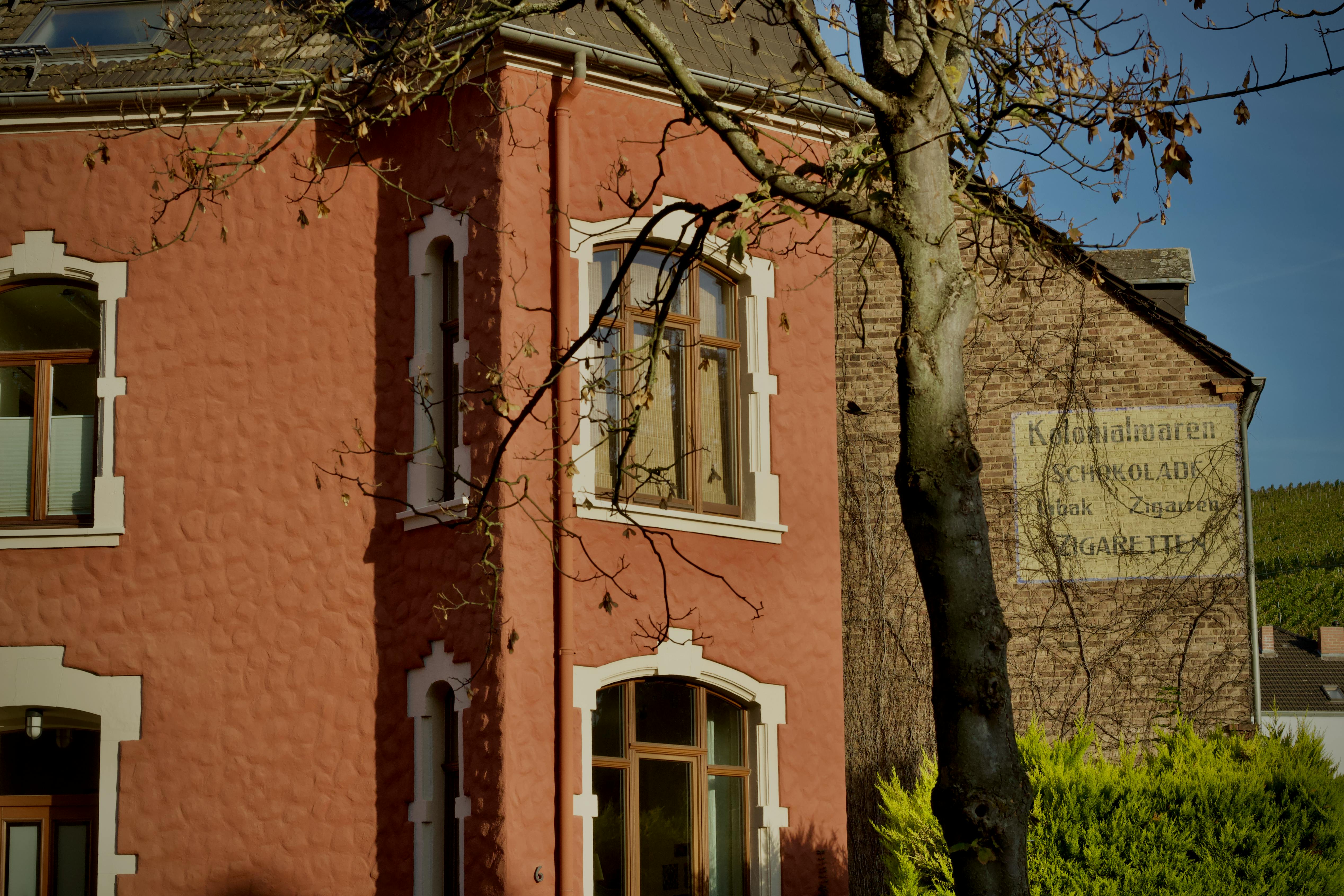 Δωρεάν Ένα γοητευτικό vintage κτίριο από τούβλα με παλιές διαφημίσεις, που αναδεικνύει αρχιτεκτονικές λεπτομέρειες μέσα σε φυσικό περιβάλλον. Φωτογραφία από στοκ φωτογραφιών