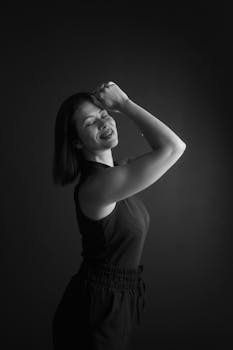 Elegant black and white portrait of a woman joyfully posing indoors.