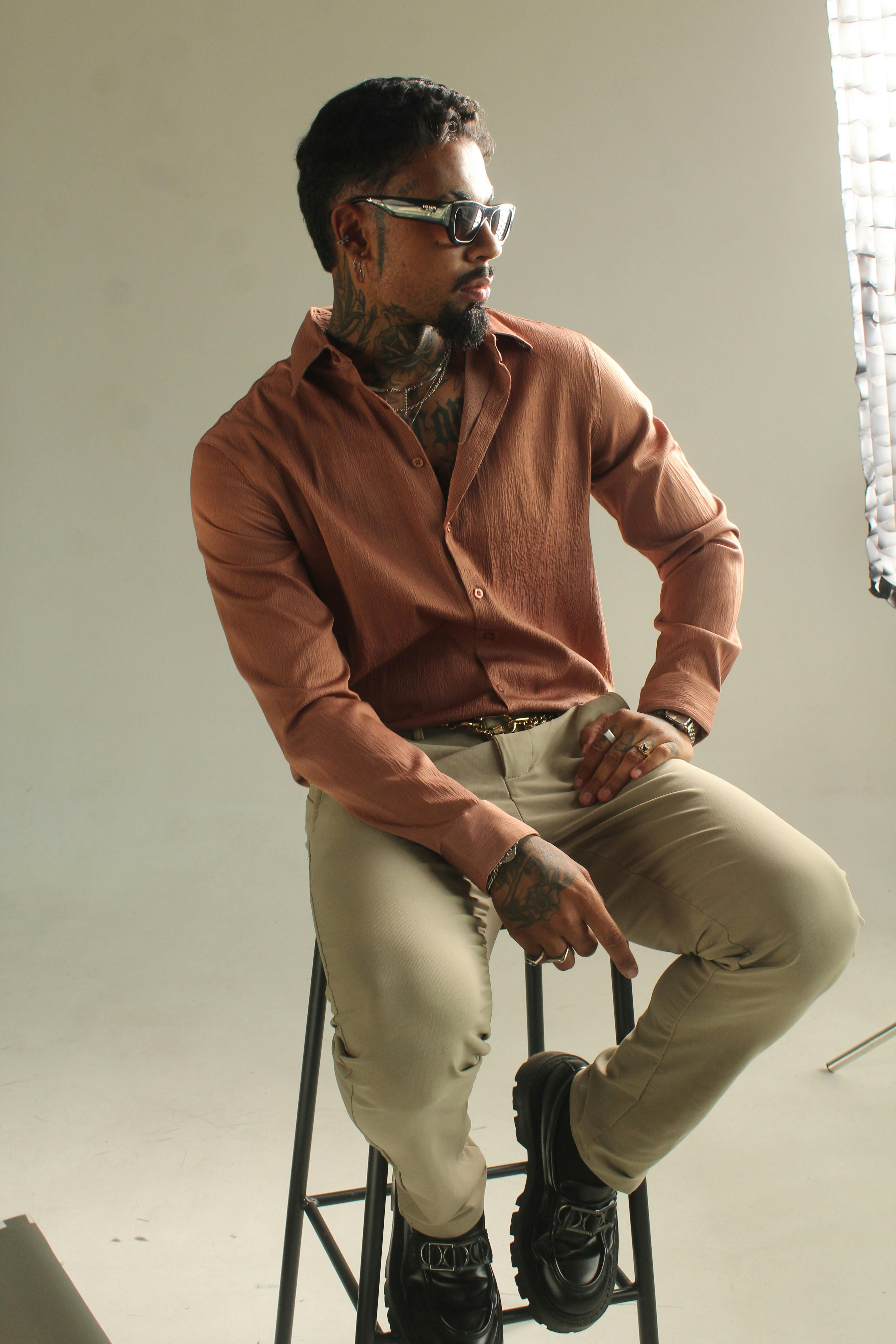 Δωρεάν Ένα μοντέρνο πορτρέτο ενός άνδρα σε στούντιο με χαλαρή ενδυμασία και αξεσουάρ. Φωτογραφία από στοκ φωτογραφιών