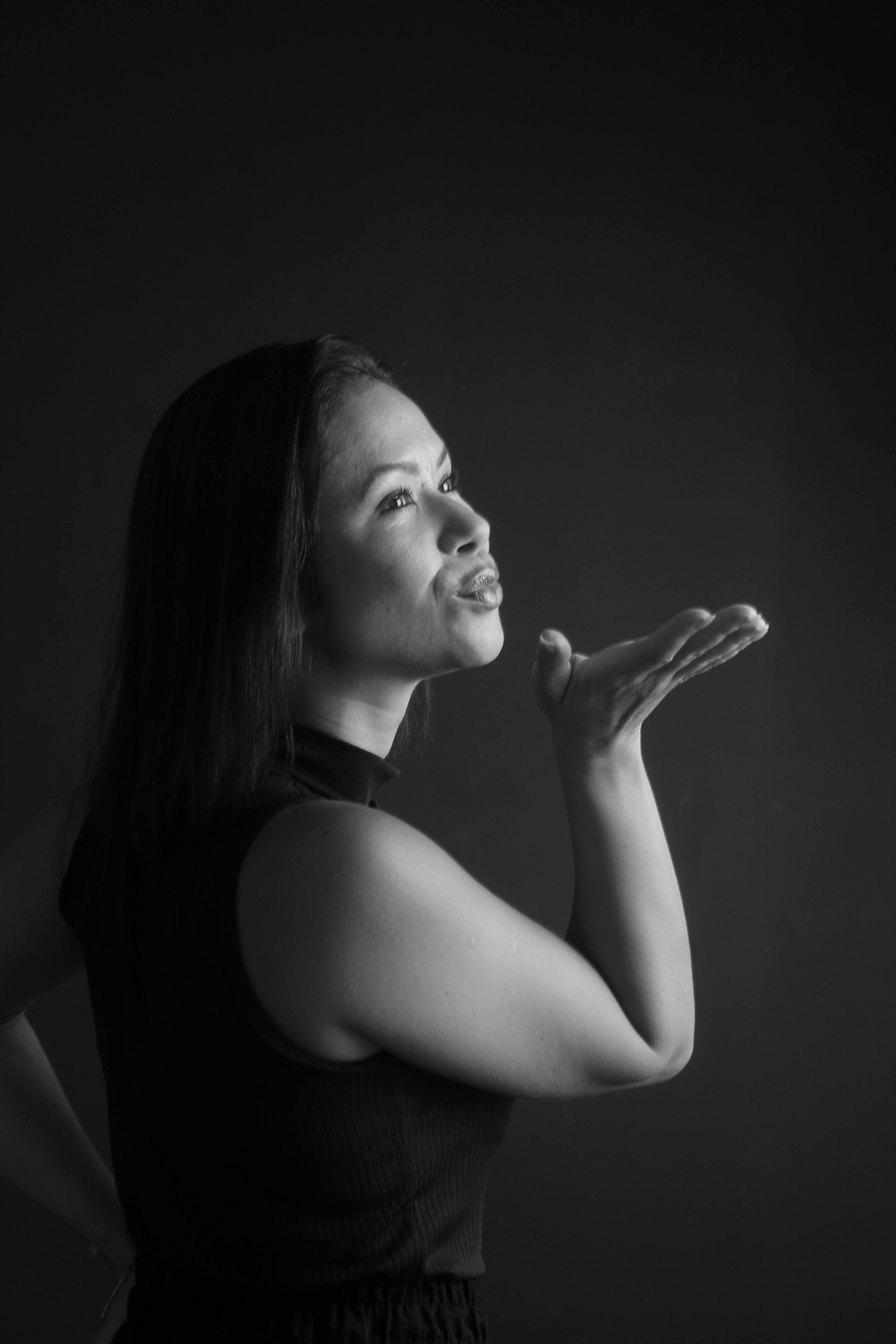 Kostenlos Elegantes Schwarz-Weiß-Porträt einer Frau, die in einem Studio einen Kuss zuwirft. Stock-Foto