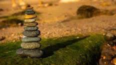 Balancing Rocks on a Sandy Beach at Sunset