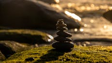 Balanced Stones on Mossy Rock at Sunset
